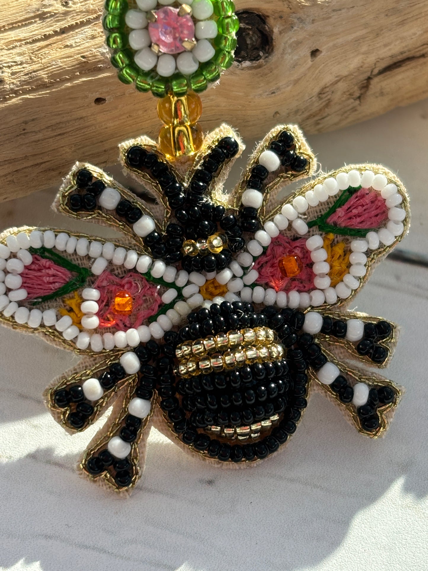 closeup shot of beaded bee earrings—handcrafted with floral embroidery, gold accents, and vibrant summer colors