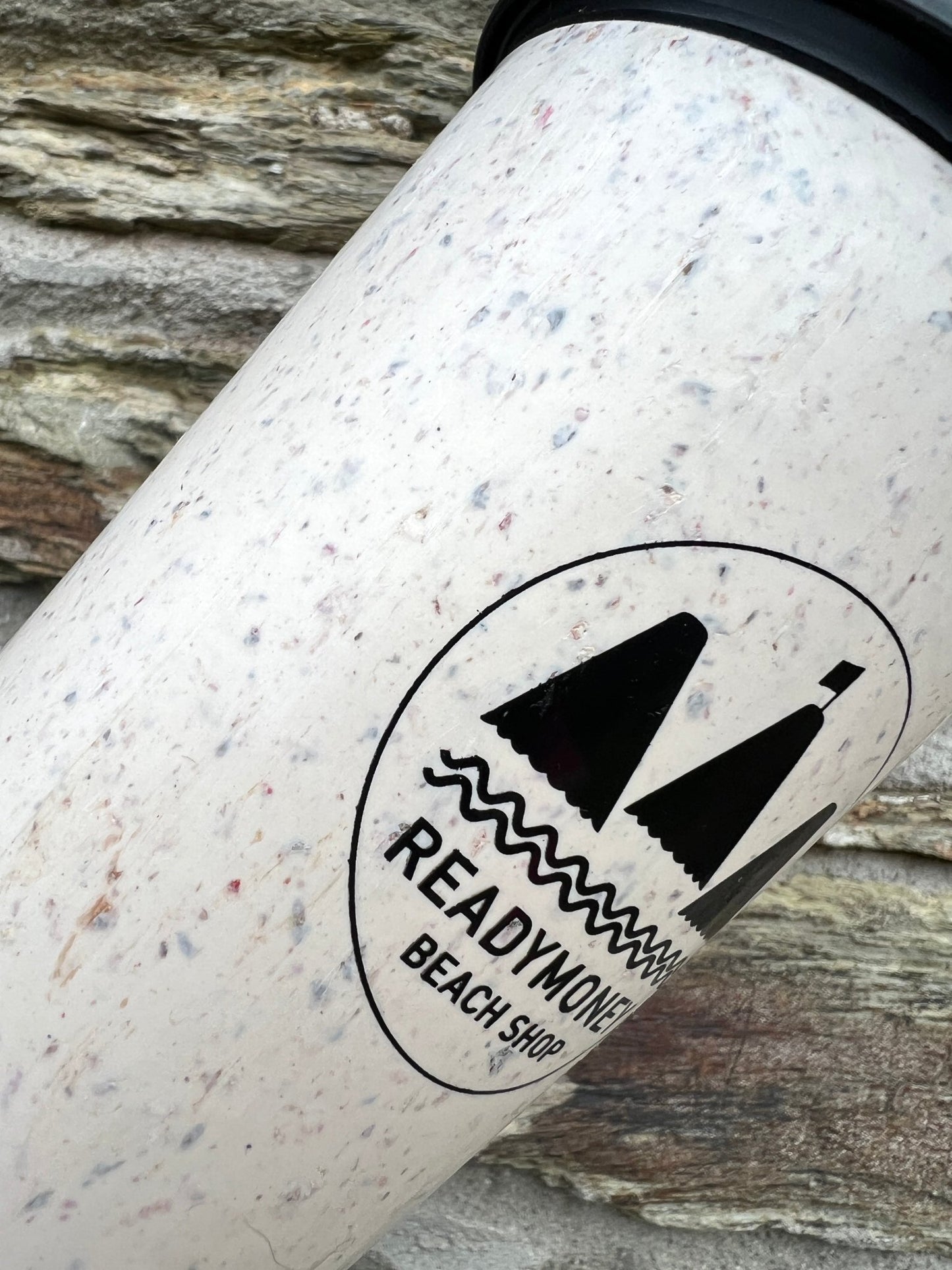 closeup shot of Circular&Co. Now Cup 12oz. Texture of recycled paper cups, 'Readymoney Beach Shop' logo, sustainable, eco-friendly