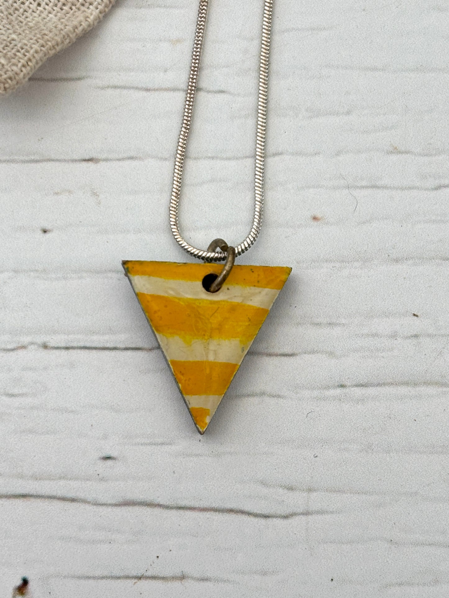 artisan yellow cream striped triangle necklace detail, hand-painted pendant, weathered white wood, coastal style