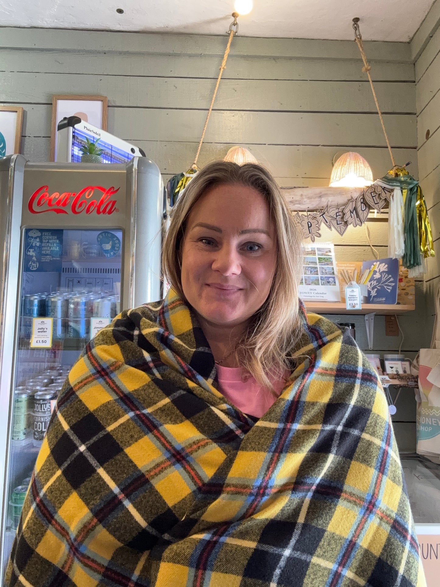 Cornish tartan scarf in yellow plaid—cozy heritage wrap styled in café setting, perfect for coastal gifting and winter warmth