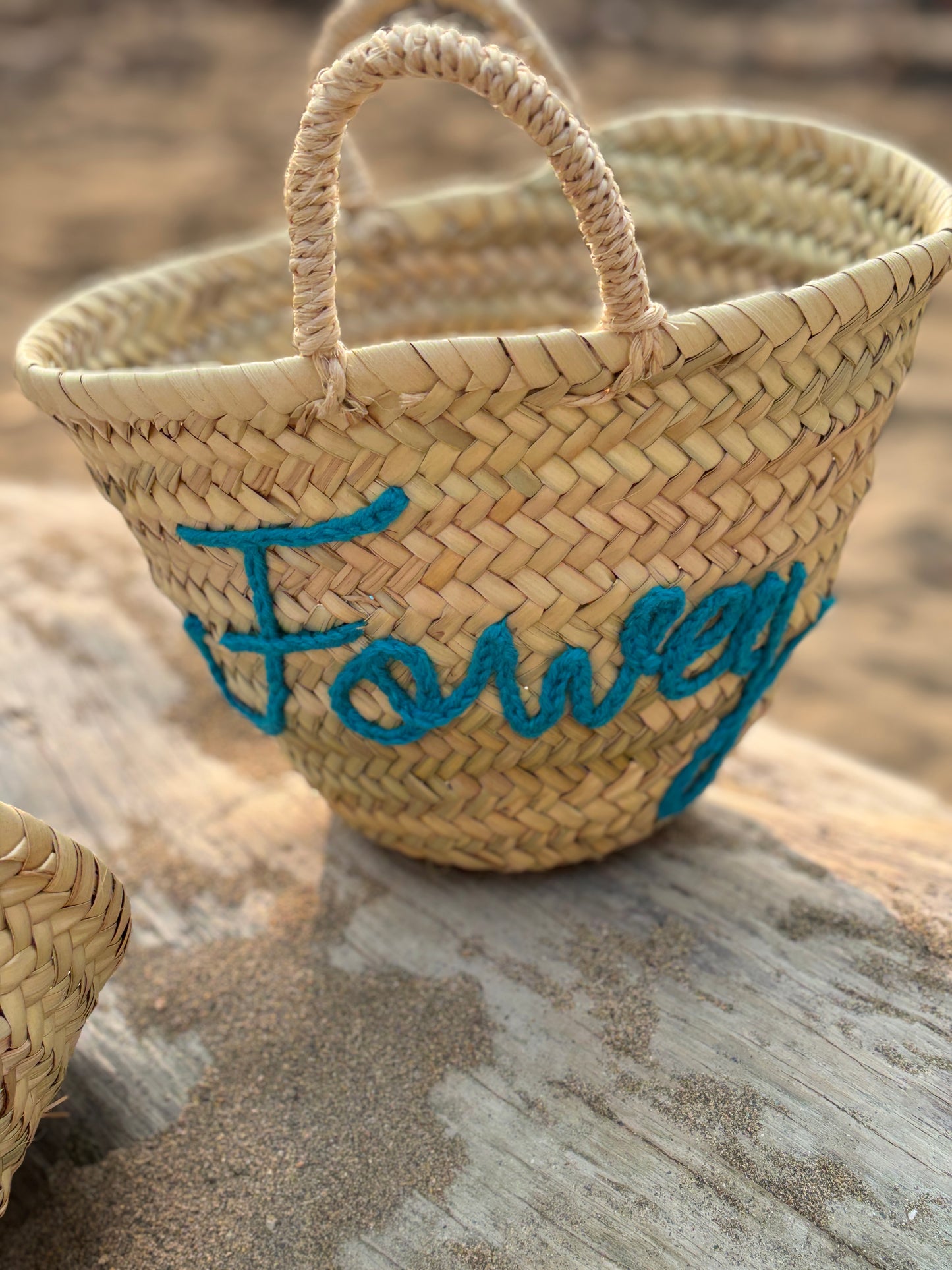 natural woven mini straw beach basket with "Fowey" embroidered in bright teal blue yarn coastal straw bag, summer tote