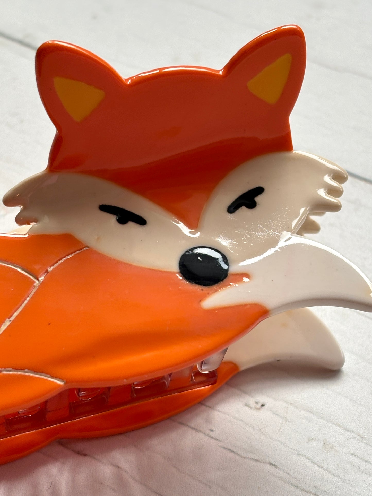 closeup shot of fox hair claw—glossy orange clip with cream accents, yellow ears, and playful woodland-inspired styling