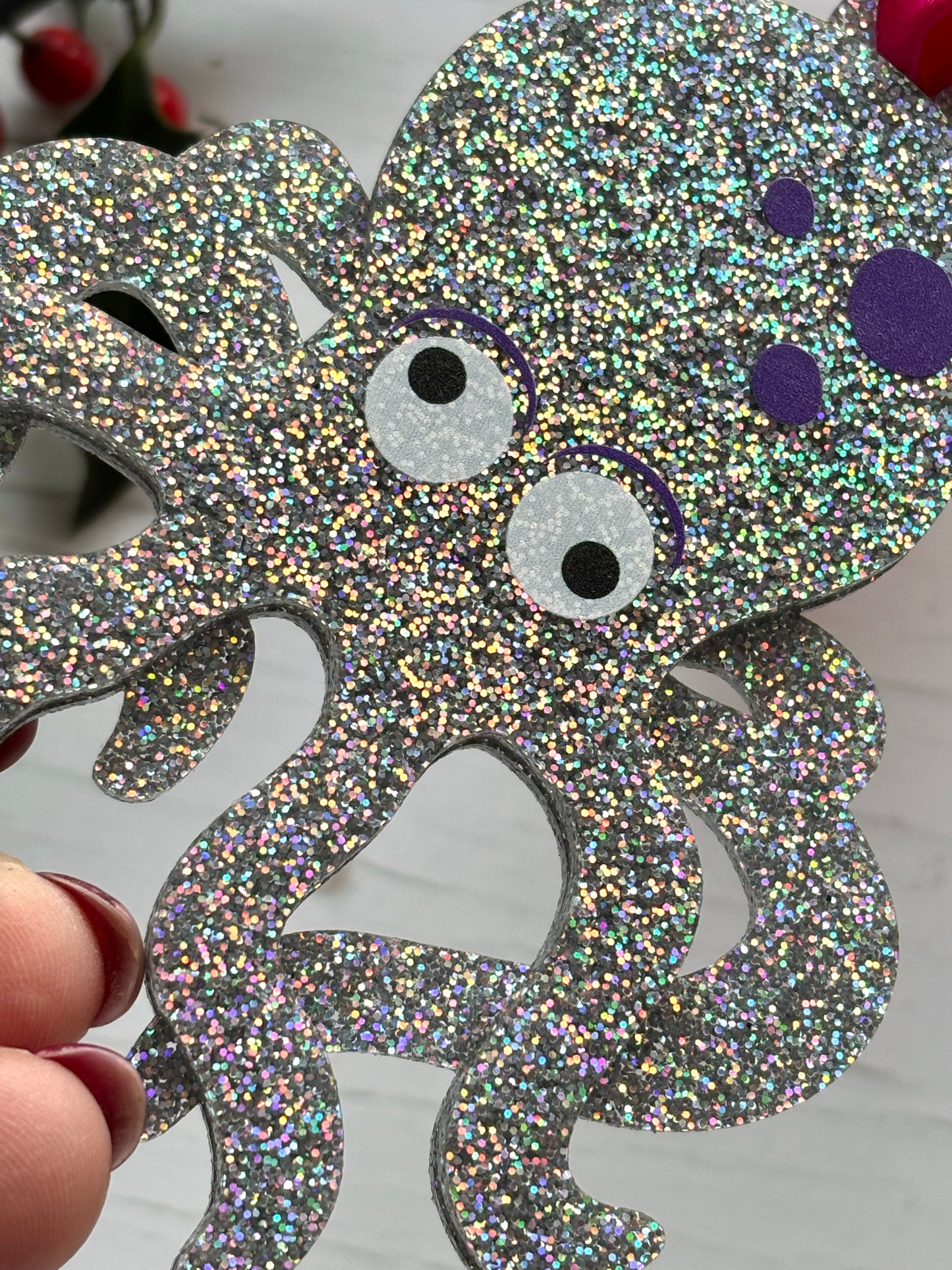 closeup shot of glittery silver octopus Christmas decoration, ocean-inspired festive ornament with purple spots and holiday sparkle