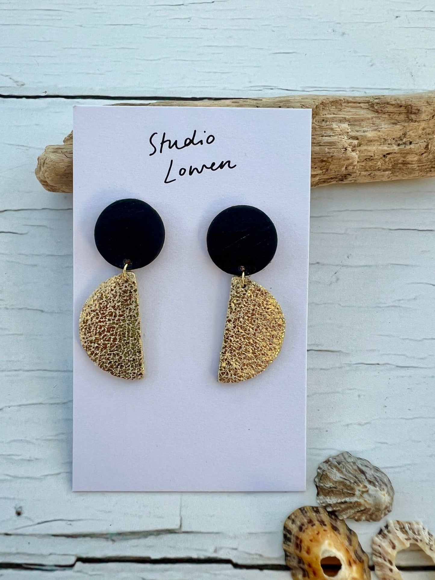 gold and black half-moon drop earrings made from textured polymer clay handmade jewellery with a modern geometric and statement style
