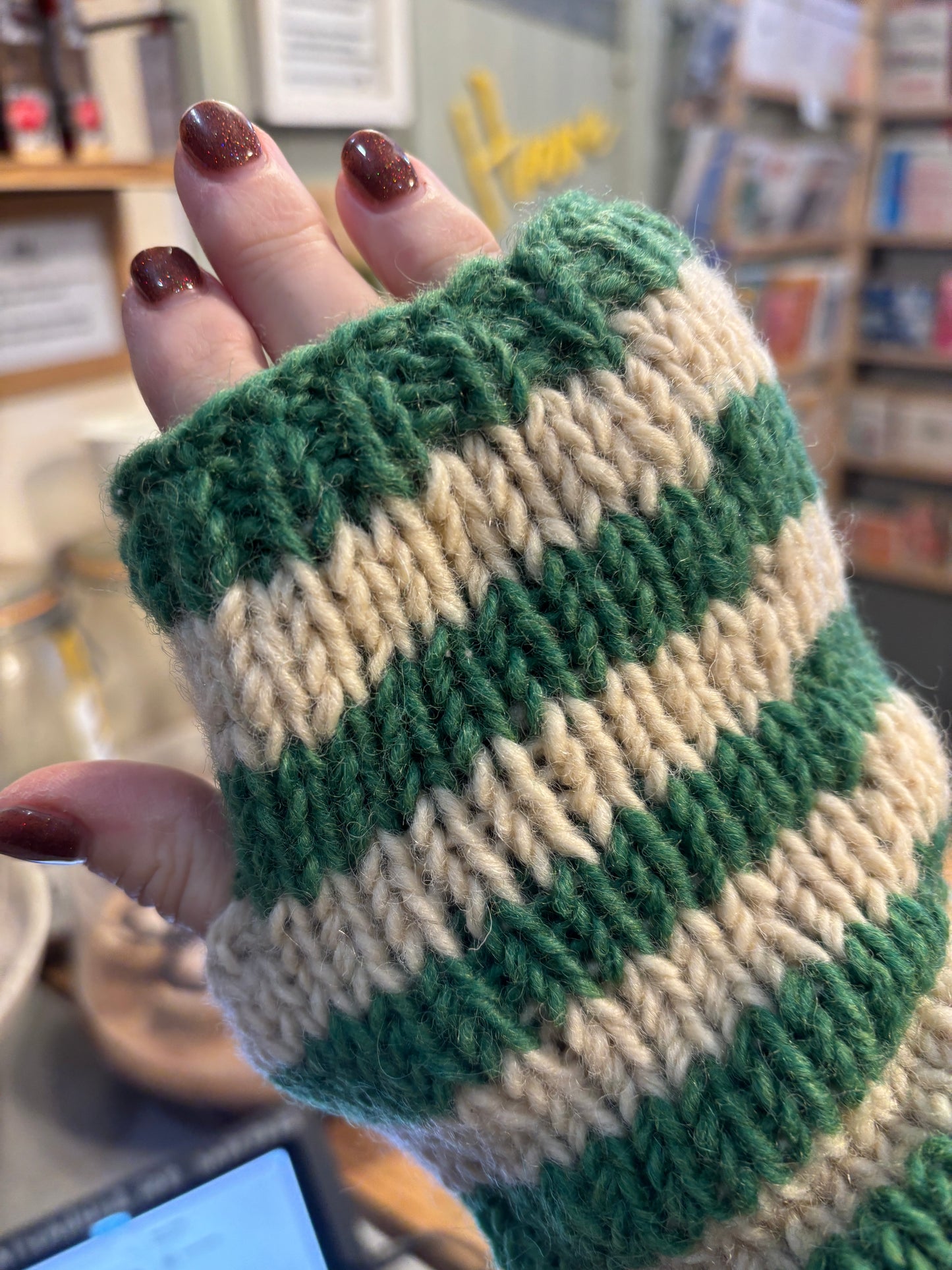 hand modeling green cream striped fingerless gloves - chunky knit wool hand warmers with thumb holes closeup