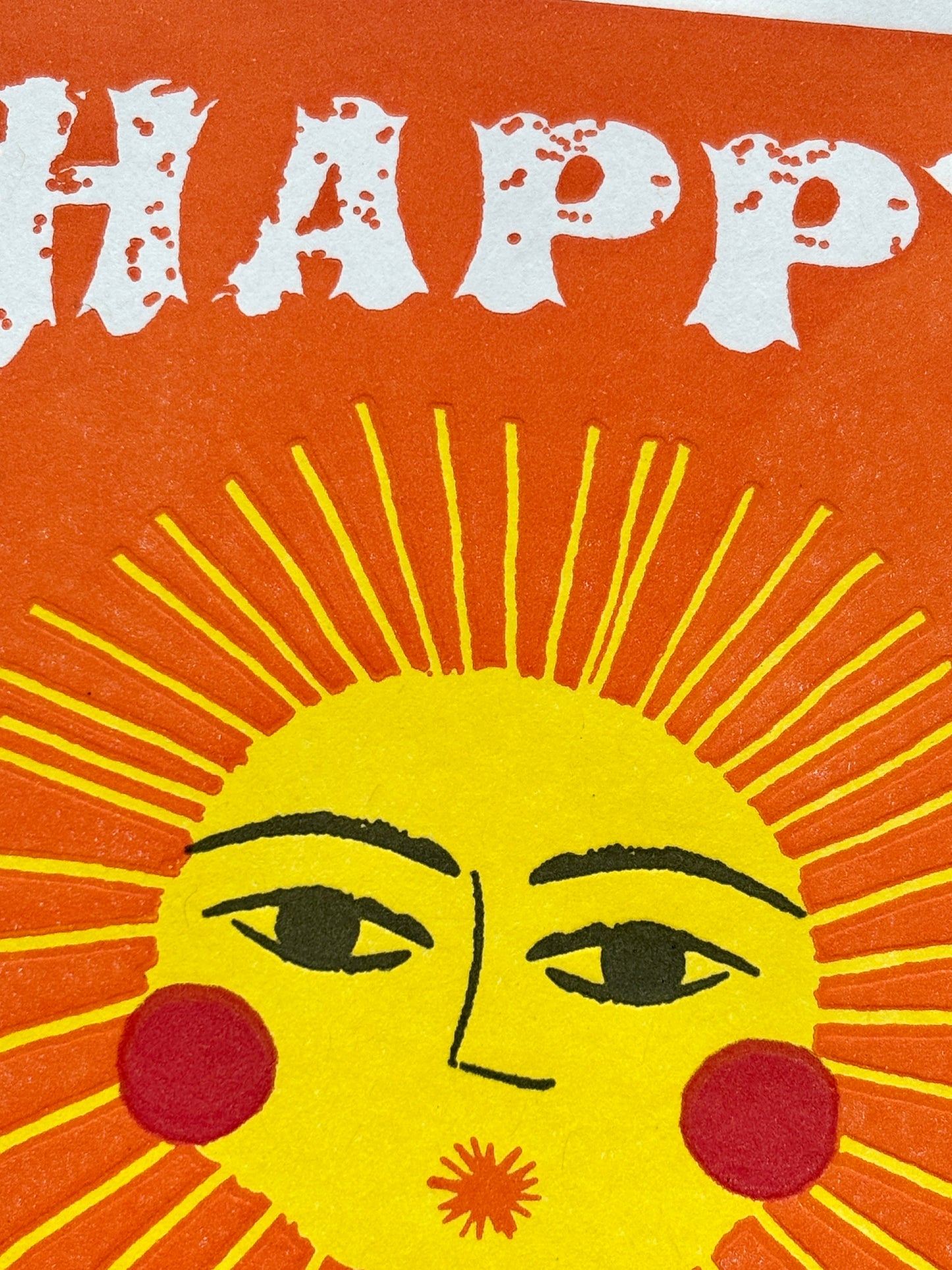 closeup shot of sunshine birthday card with bold sun face and white text on orange, perfect for cheerful coastal-themed gifting