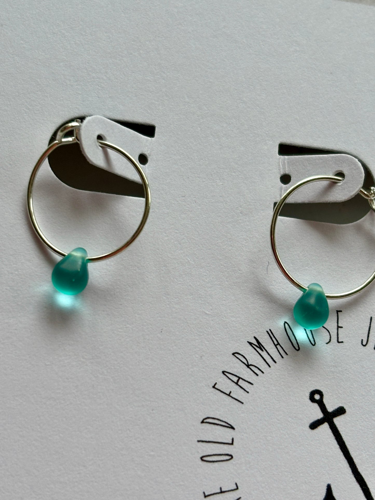 closeup shot of aqua glass teardrop bead mini silver hoop earrings handmade, unique, tiny jewelry accessory