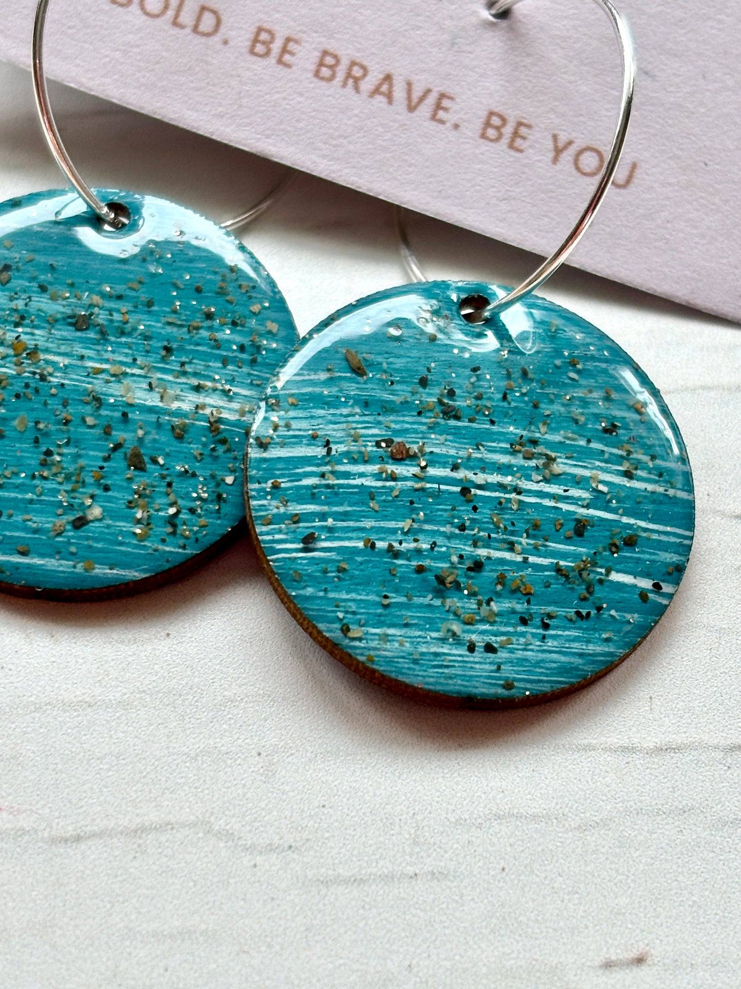 teal sterling silver hoop earrings closeup handmade resin with a coastal sand texture boho-chic and modern statement jewelry