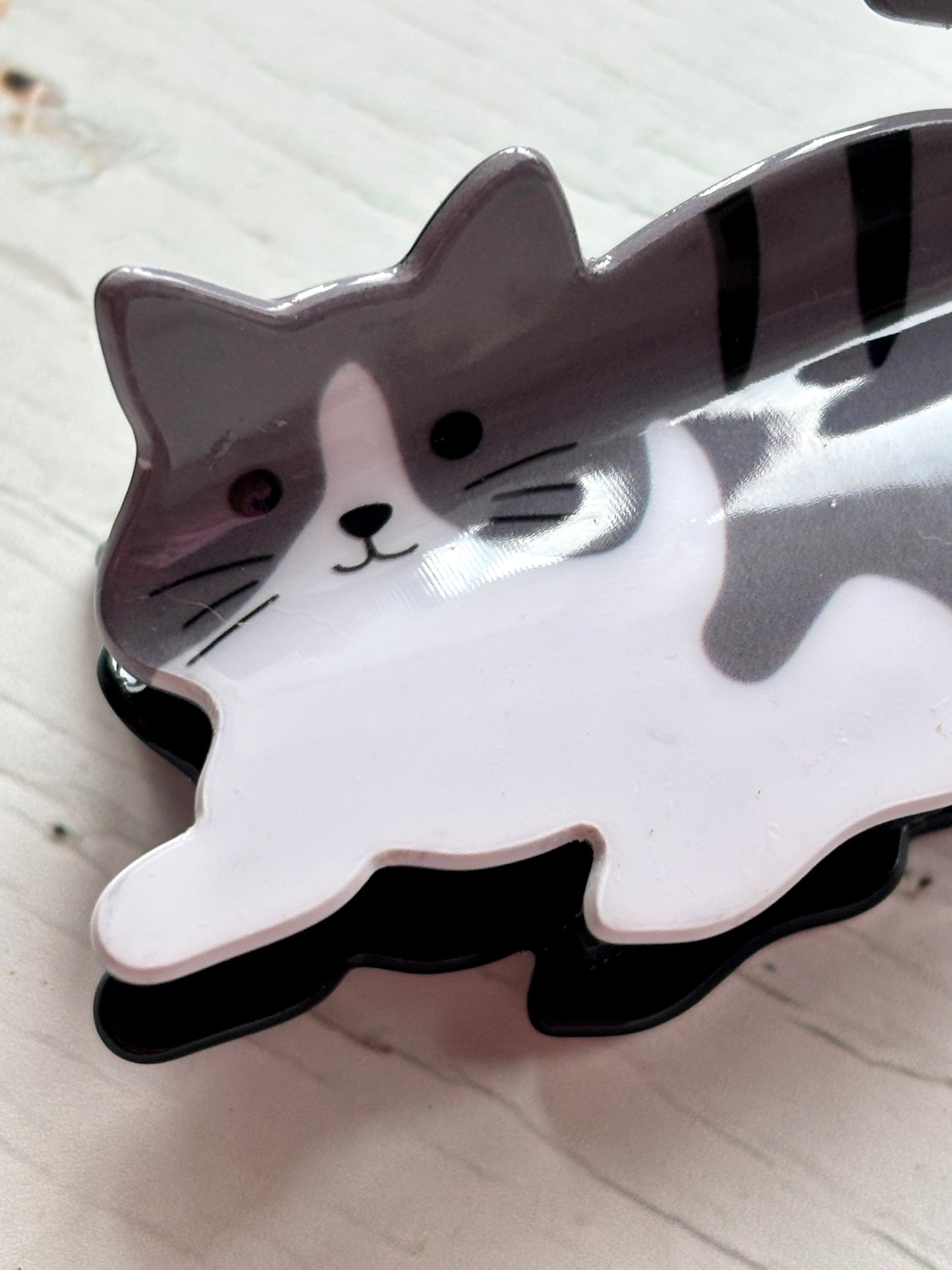 closeup shot of the adorable grey and white tabby cat hair claw clip face and front paw detail cute pet novelty hair accessory