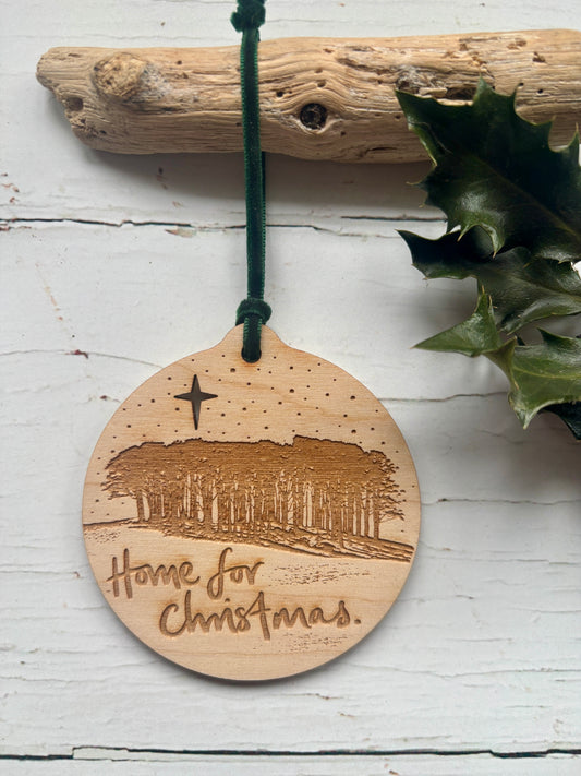 round laser etched christmas decoration depicting the nearly home trees