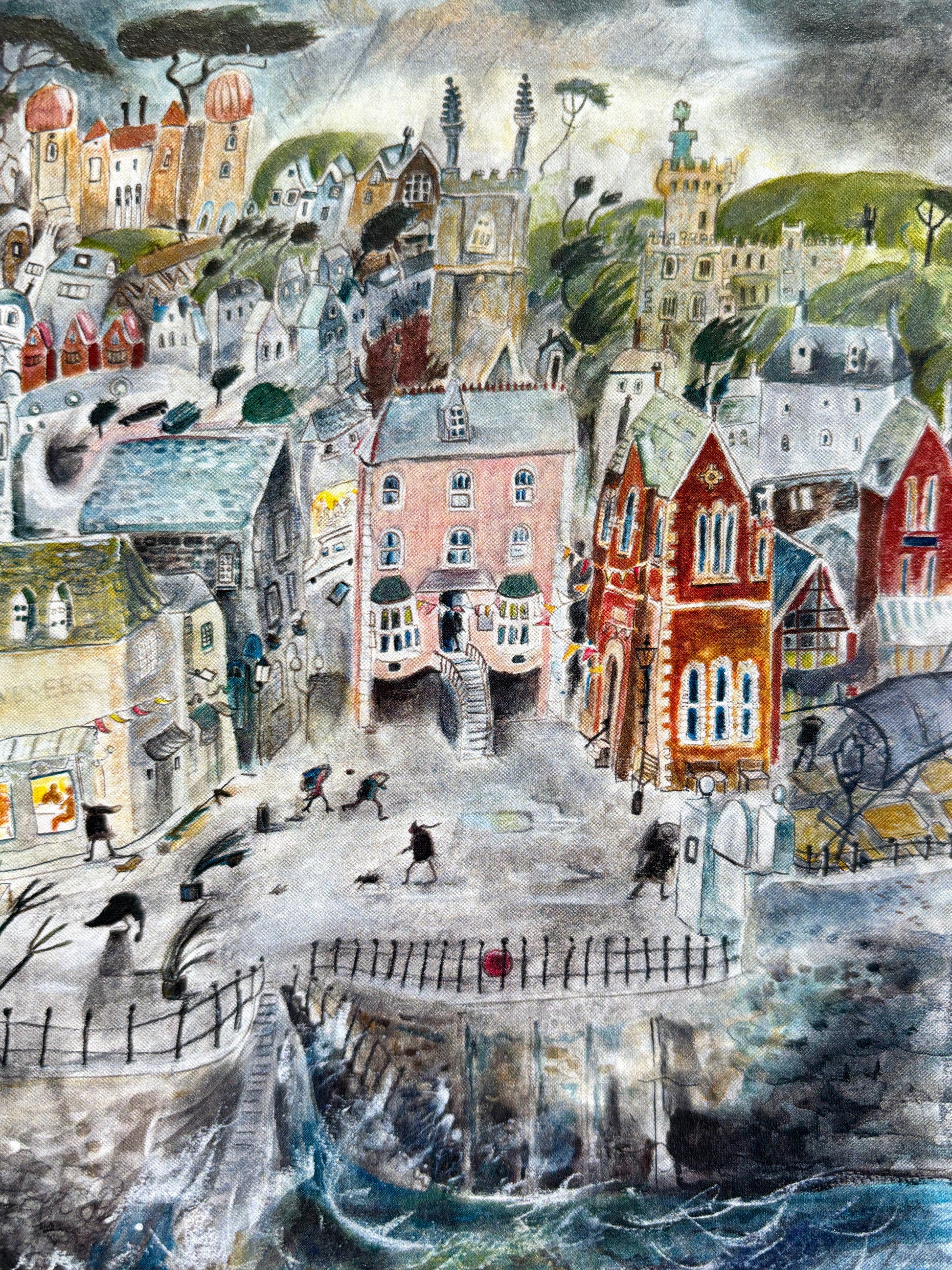 closeup shot of “A Stormy Day” greeting card featuring a whimsical seaside village in wind and rain, coastal art design