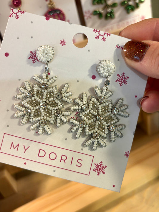 a pair of white and silver beaded christmas earrings shaped like snowflakes