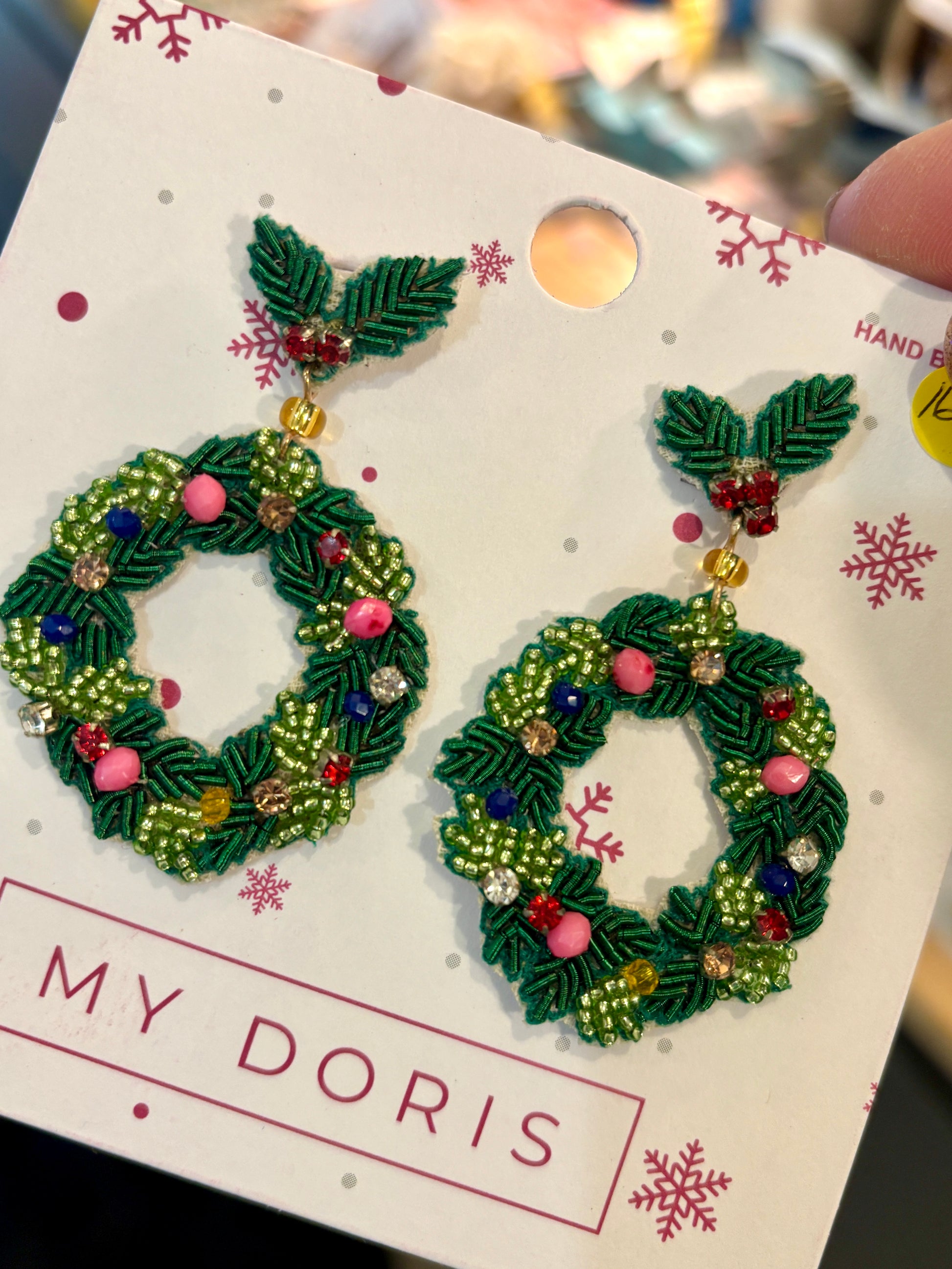 a pair of beaded christmas wreath shaped earrings