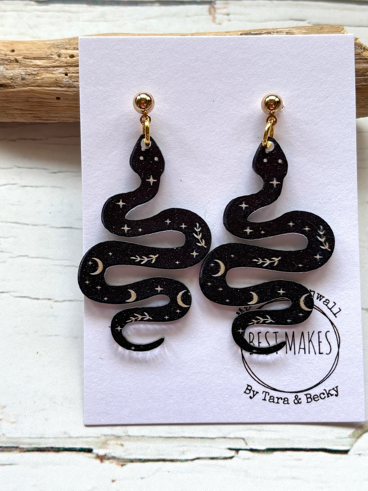 black polymer resin snake earrings witchy celestial jewelry with moon and star print gothic serpent fashion accessories