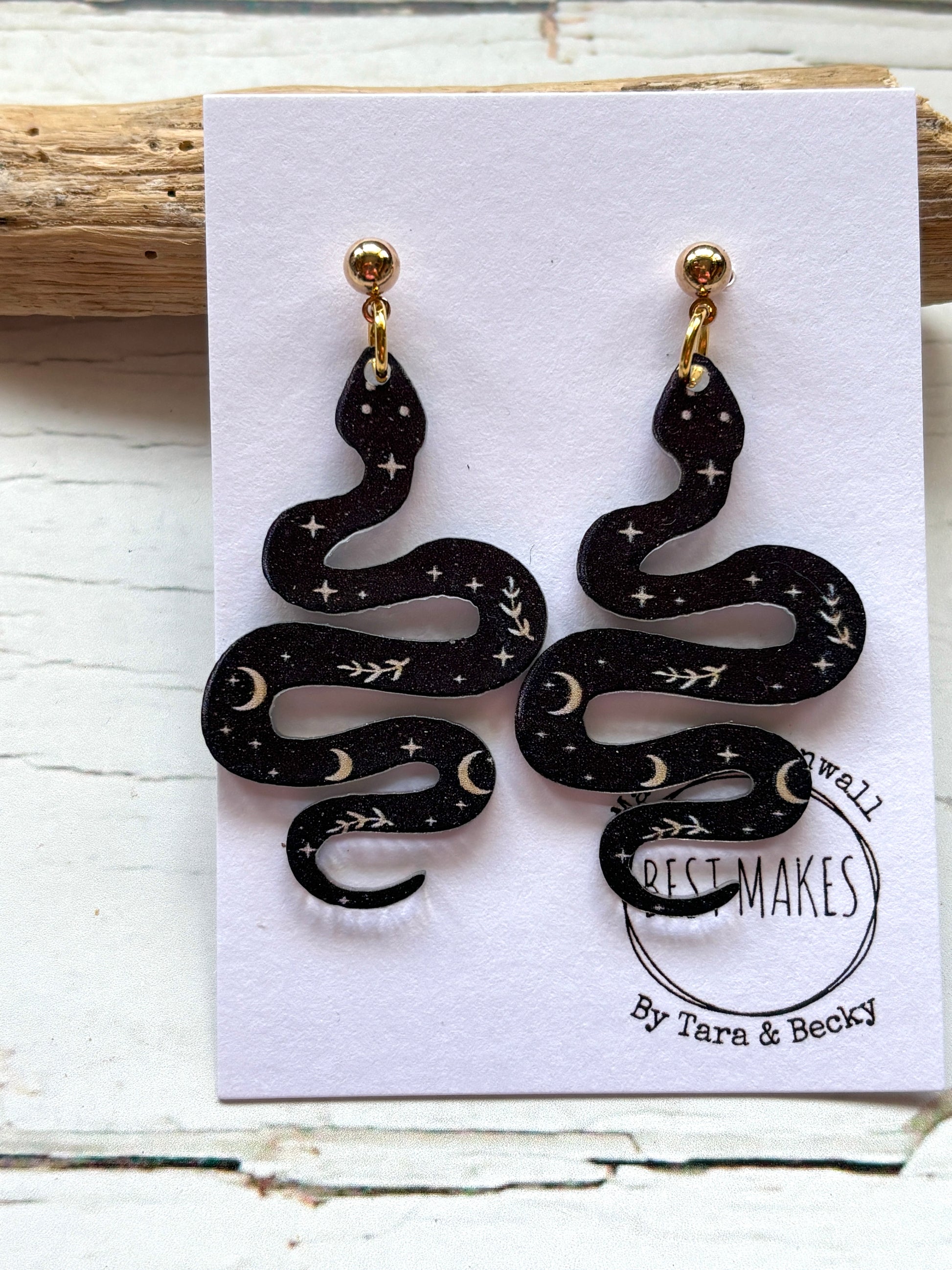 black polymer resin snake earrings witchy celestial jewelry with moon and star print gothic serpent fashion accessories