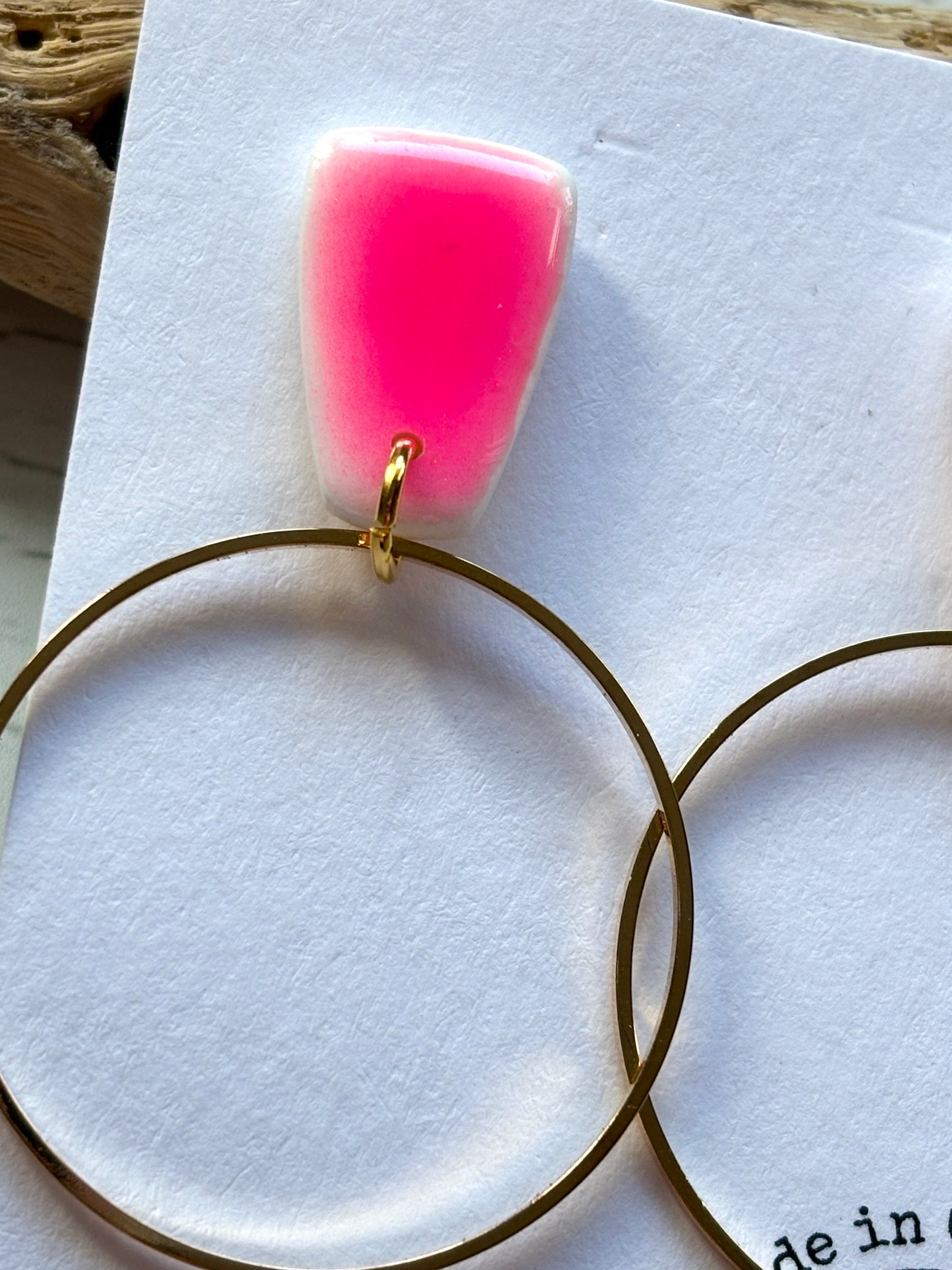 closeup shot of gold hoop earring polymer resin stud with a neon pink ombre effect handmade modern jewelry and fashion accessory detail
