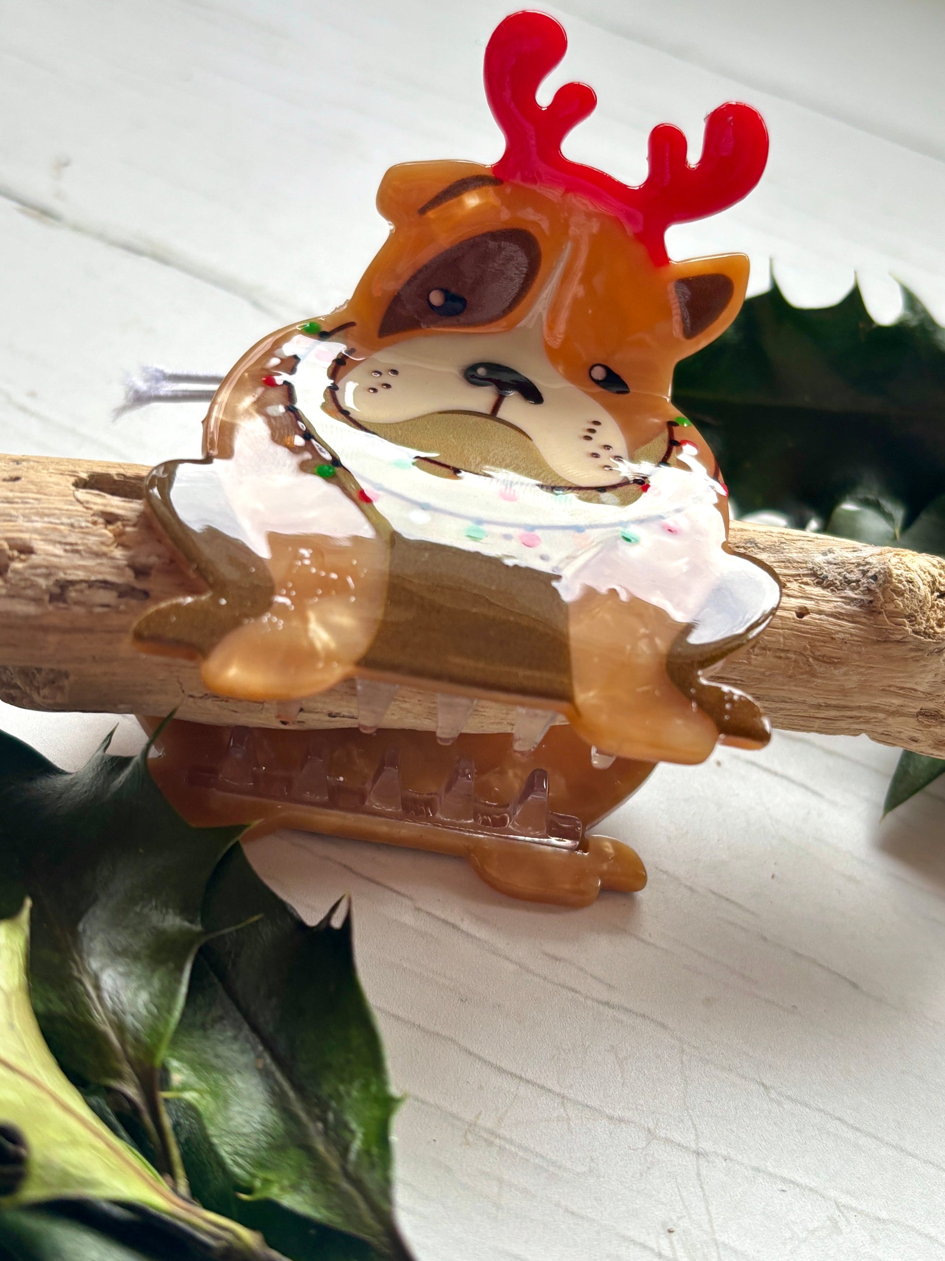 closeup shot of Christmas bulldog hair claw brown and white dog with a red reindeer antler headband Festive novelty pet accessory