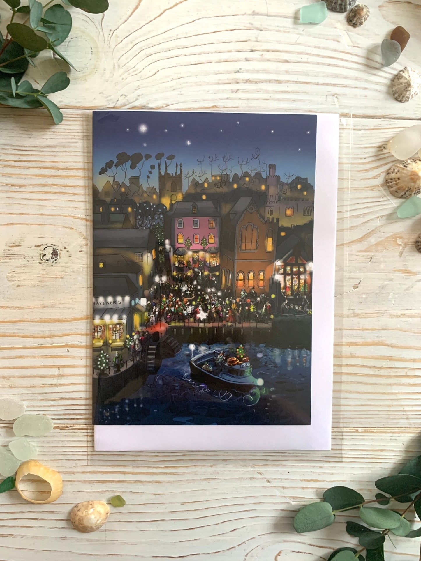 Christmas on Town Quay greeting card artwork of a festive seaside town with lights and a decorated boat Cornish holiday cards