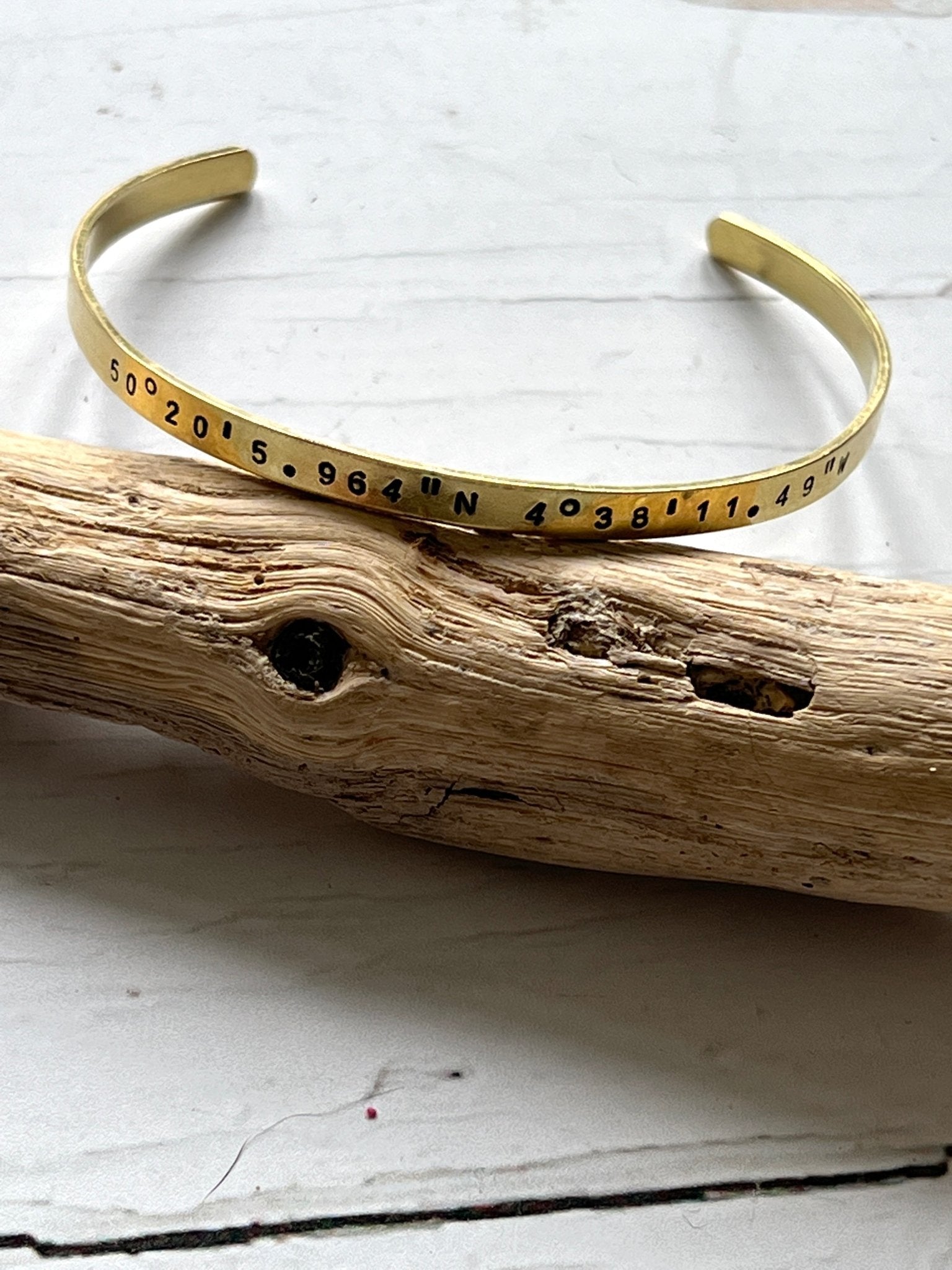 hand-stamped brass coordinate bangle, latitude longitude jewelry, personalized memorial gift, rustic driftwood display