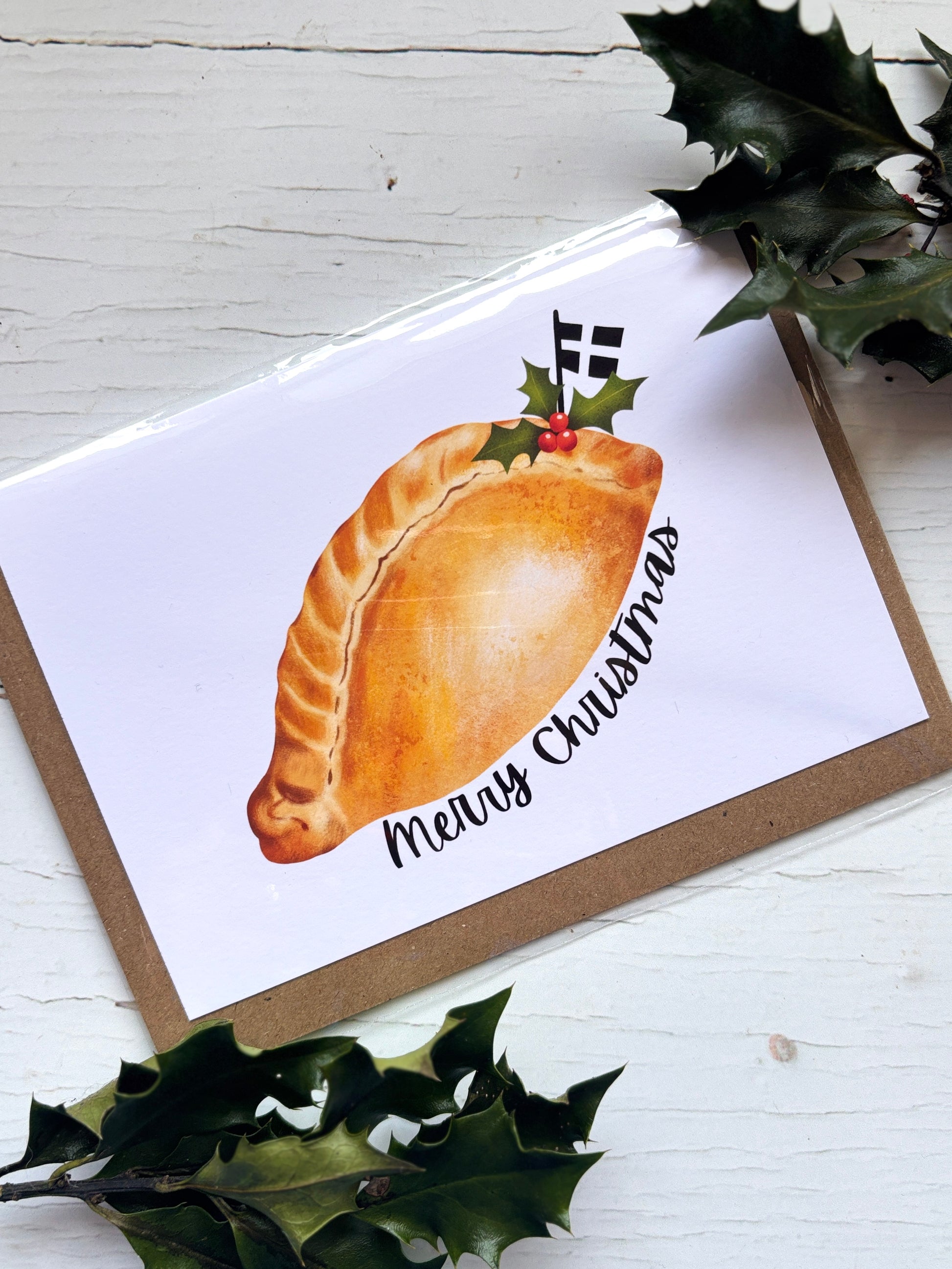 Cornish Christmas card featuring traditional pasty with holly and flag, festive “Merry Christmas” text—ideal regional holiday gift