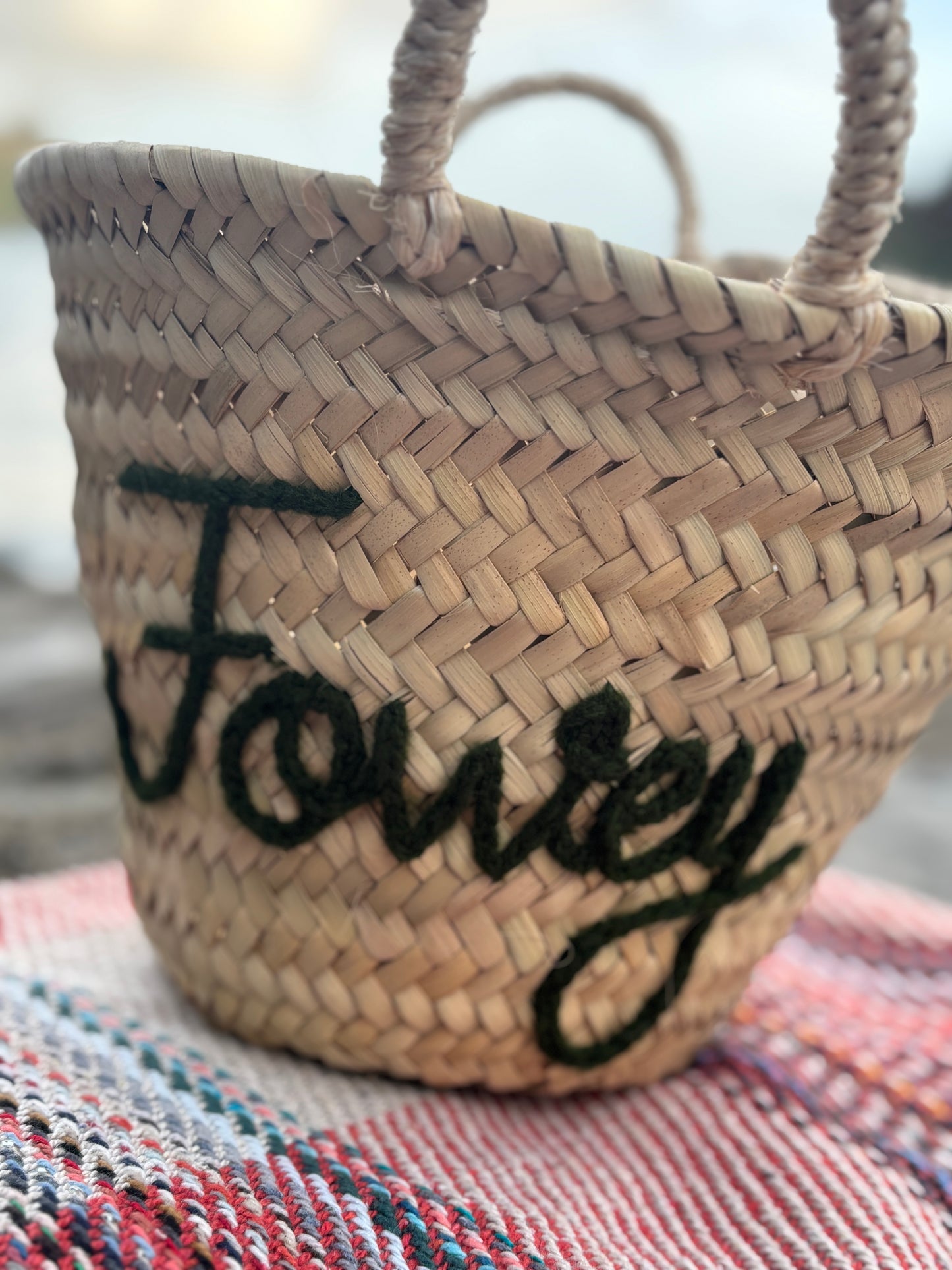handmade Fowey straw basket with dark green embroidery woven beach bag or luxury coastal gift hamper accessory for seaside decor
