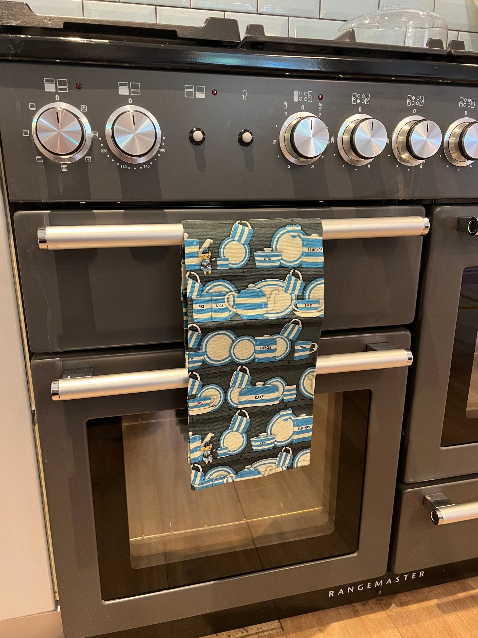 blue striped Cornish crockery tea towel hanging on black rangemaster oven, modern kitchen styling, coastal decor