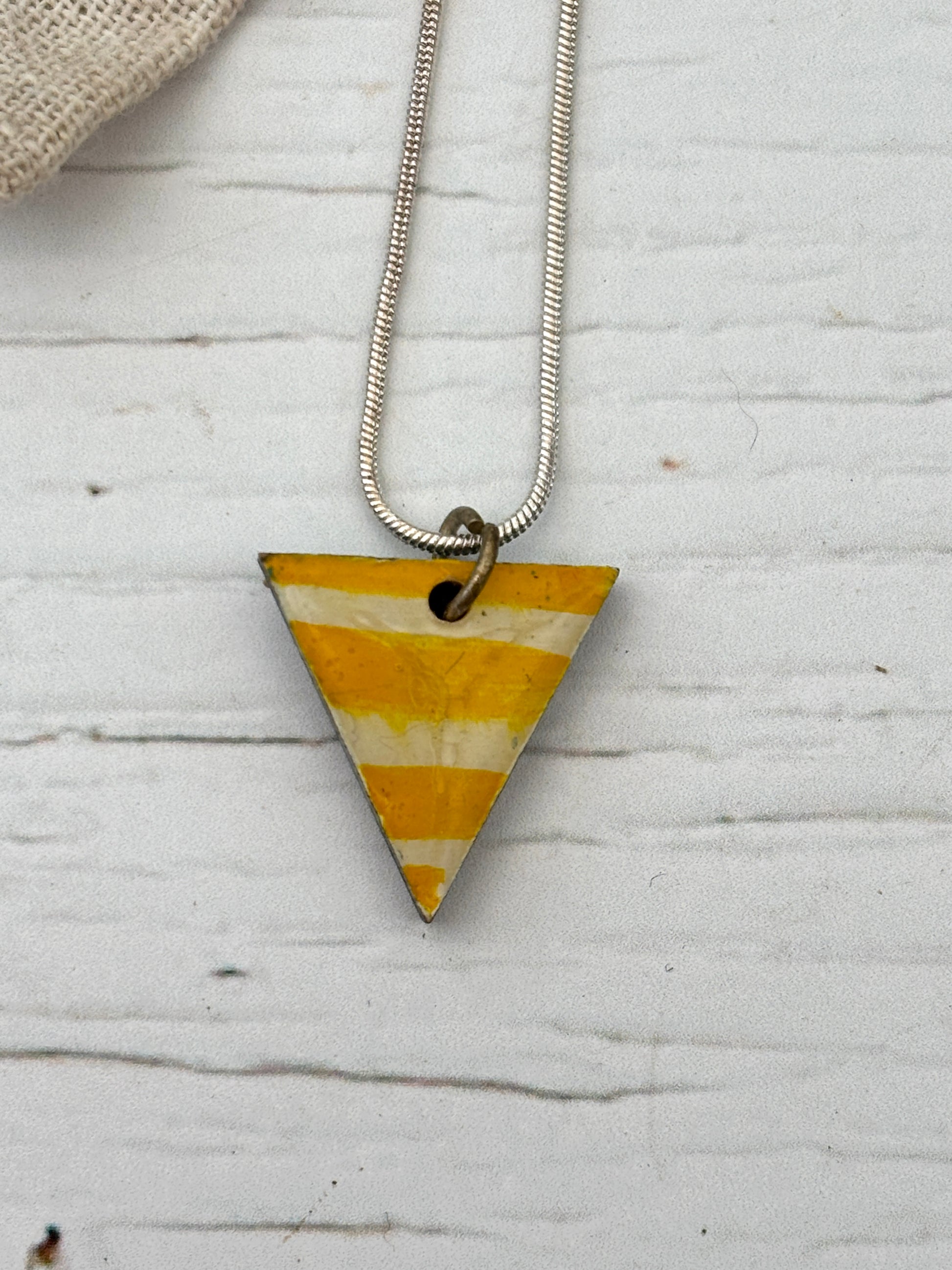 artisan yellow cream striped triangle necklace detail, hand-painted pendant, weathered white wood, coastal style
