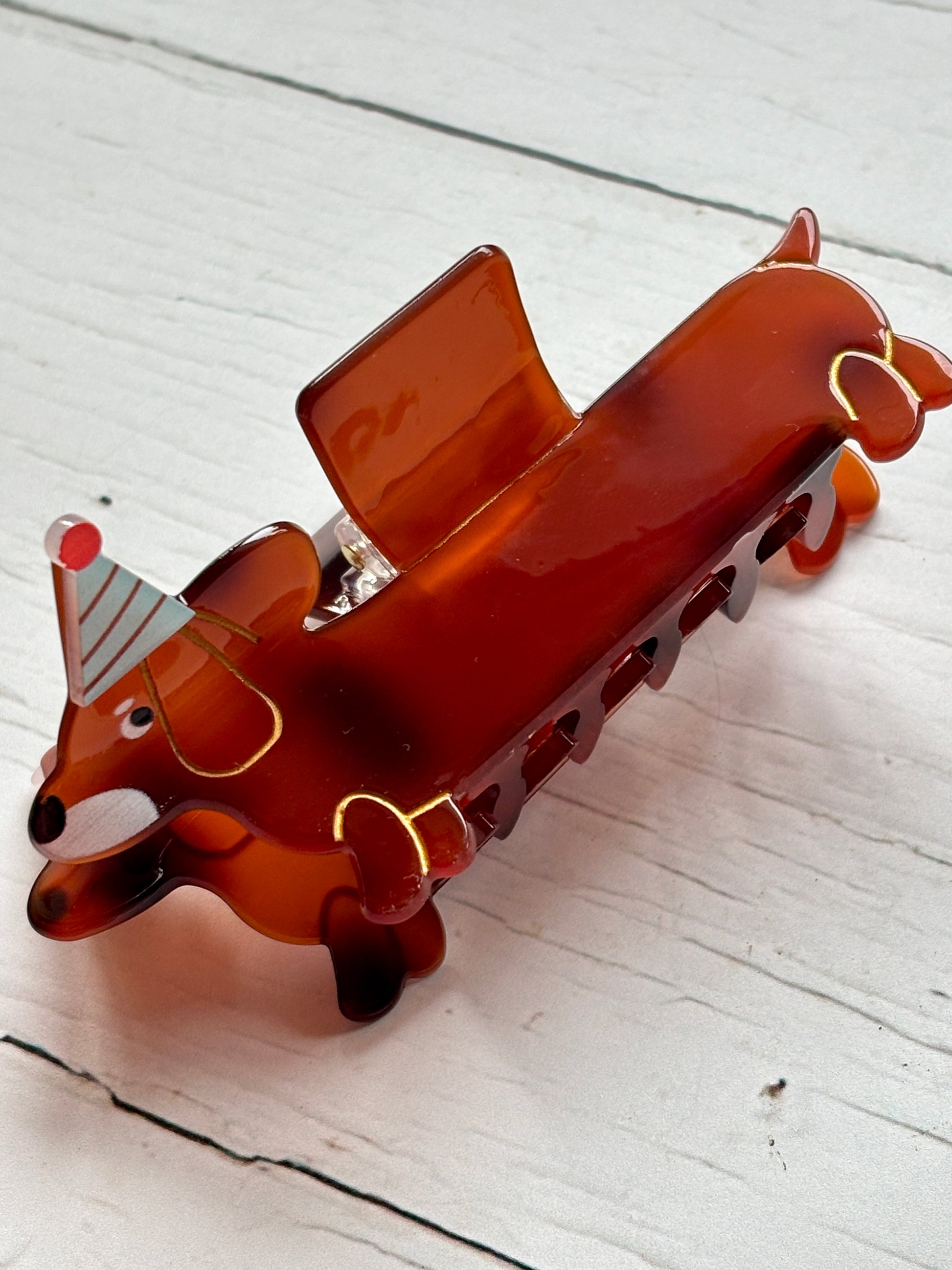 dachshund dog hair claw—glossy brown clip with party hat, gold accents, and secure grip for festive everyday styling
