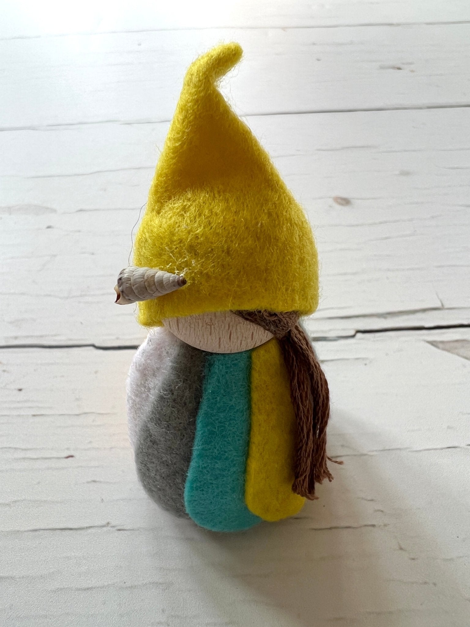 closeup shot of Daphne the Readymoney Piskie handmade wooden doll with yellow felt hat and seashell detail Cornish folklore decorative gift