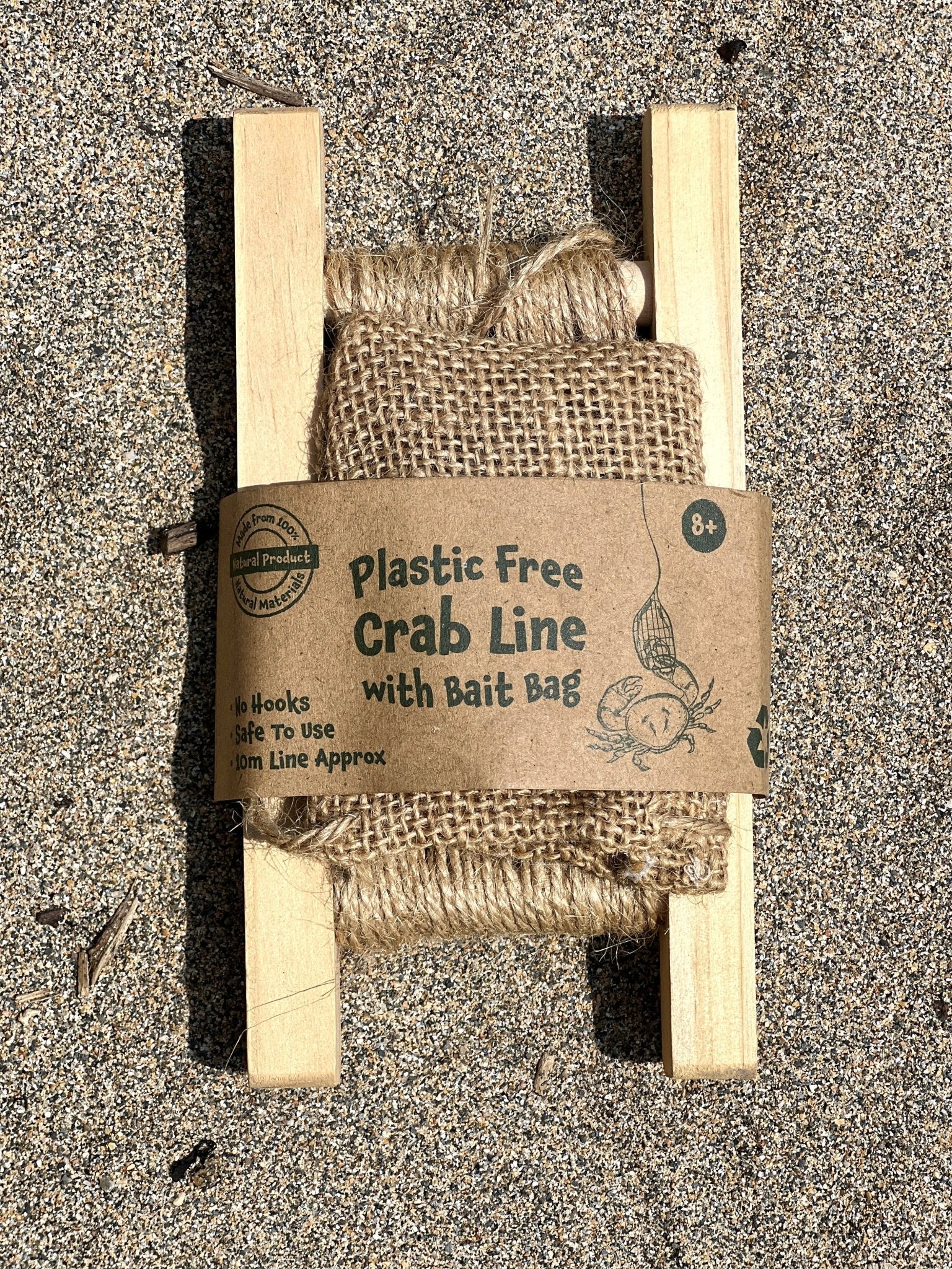 plastic-free wooden crabbing line with natural jute bait bag - sustainable beach fishing equipment on sand