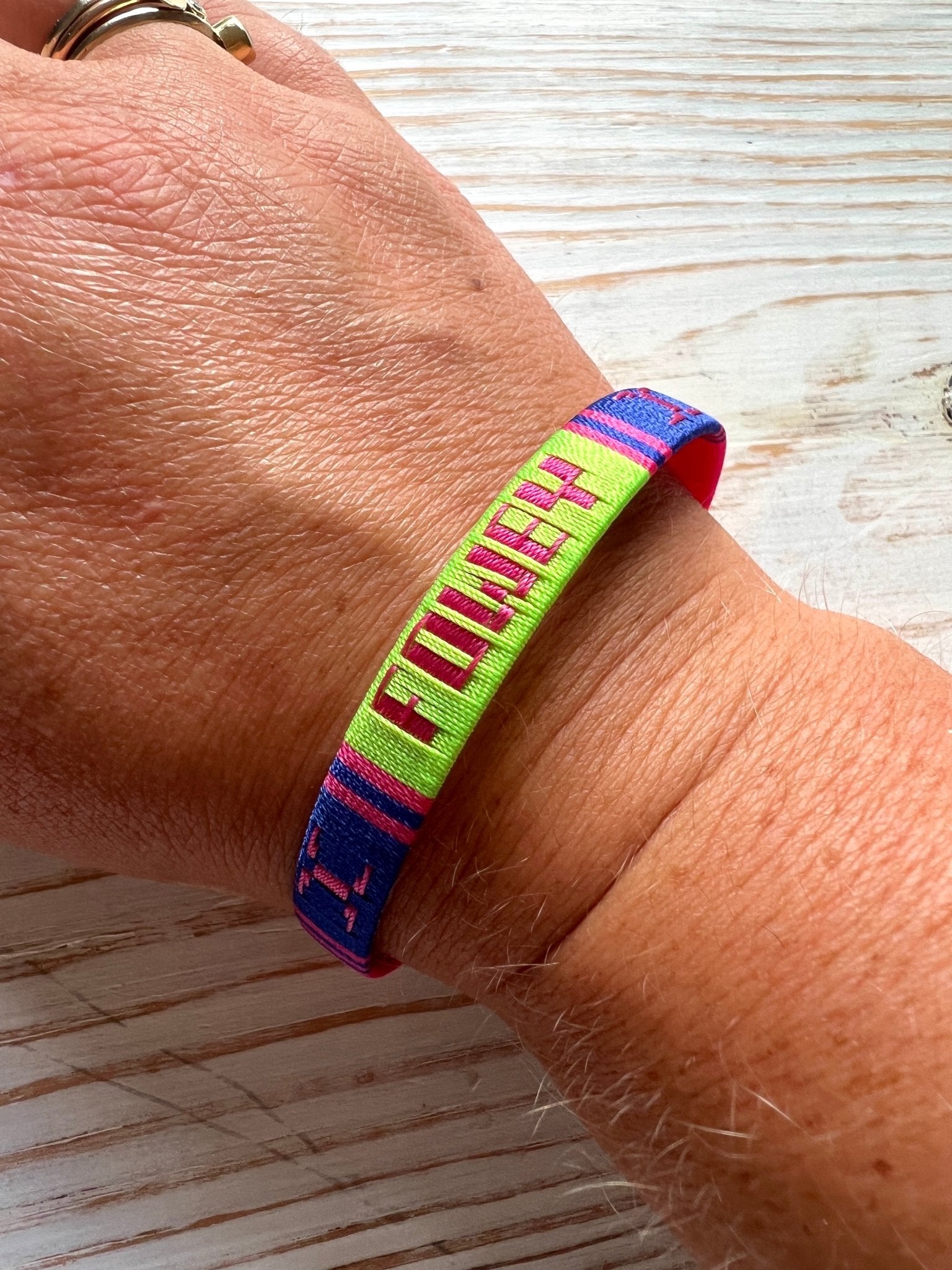 Fowey souvenir bracelet woven adjustable band in bright neon colors (green, pink, blue) lifestyle wrist shot, perfect Cornwall gift