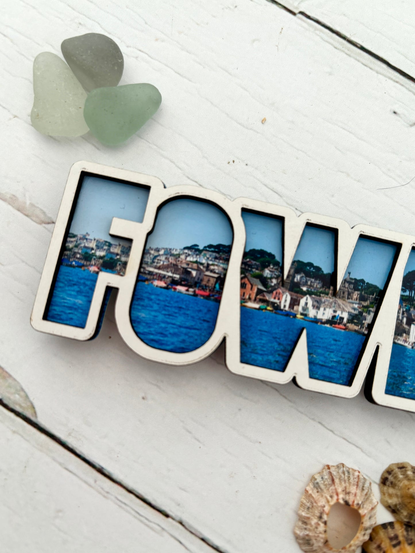 Fowey photo magnet closeup of the Fowey word cut-out, featuring the coastal townscape photo inlay wooden souvenir for the refrigerator