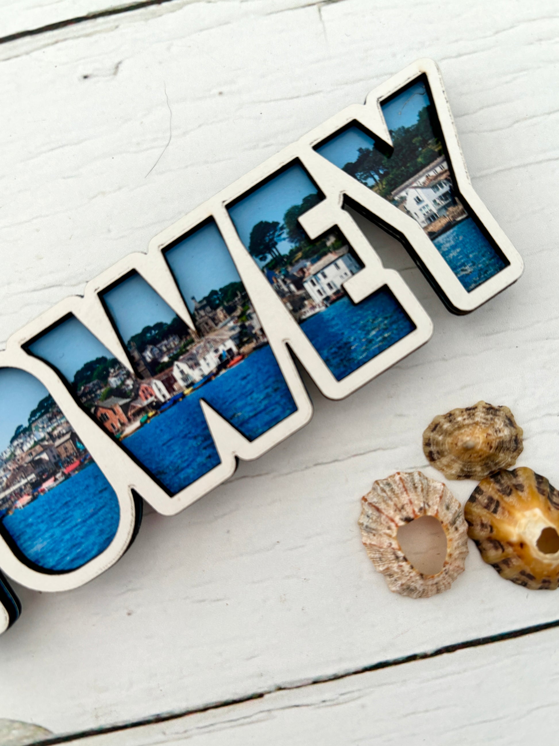close up shot of Fowey magnet word art magnet detail showing the coastal townscape photo infill in the 'EY' letters wooden souvenir and fridge decor