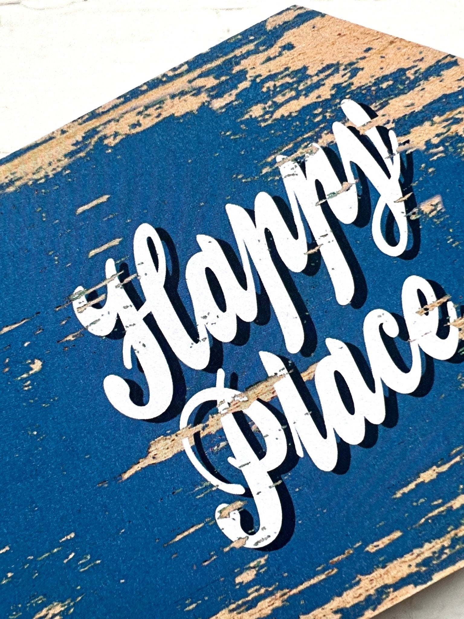 closeup shot of blue Fowey arrow sign with “Happy Place” text, rustic coastal decor, charming UK travel keepsake