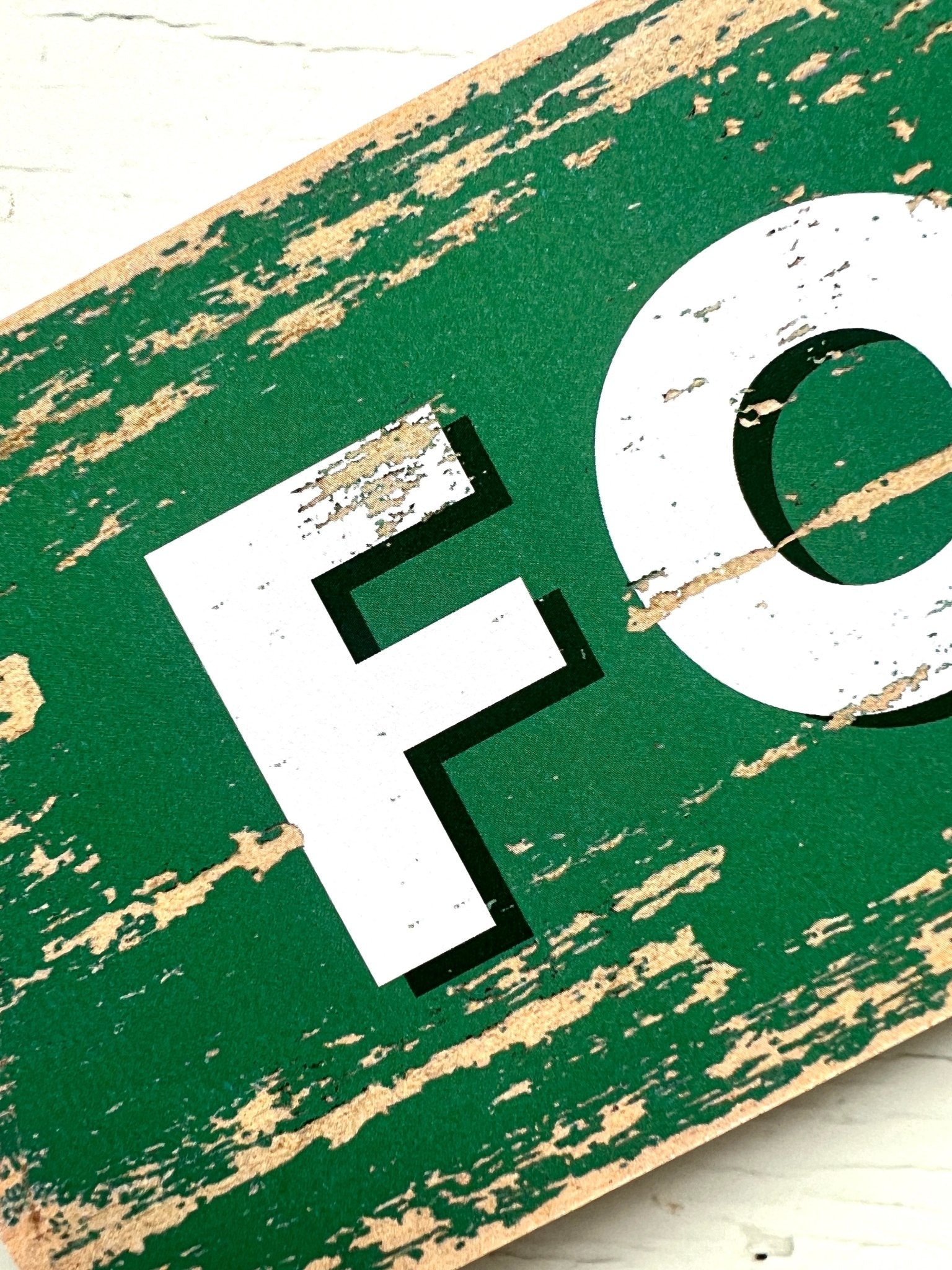 closeup shot of green Fowey arrow sign with “Happy Place” text, rustic coastal decor, charming UK travel keepsake