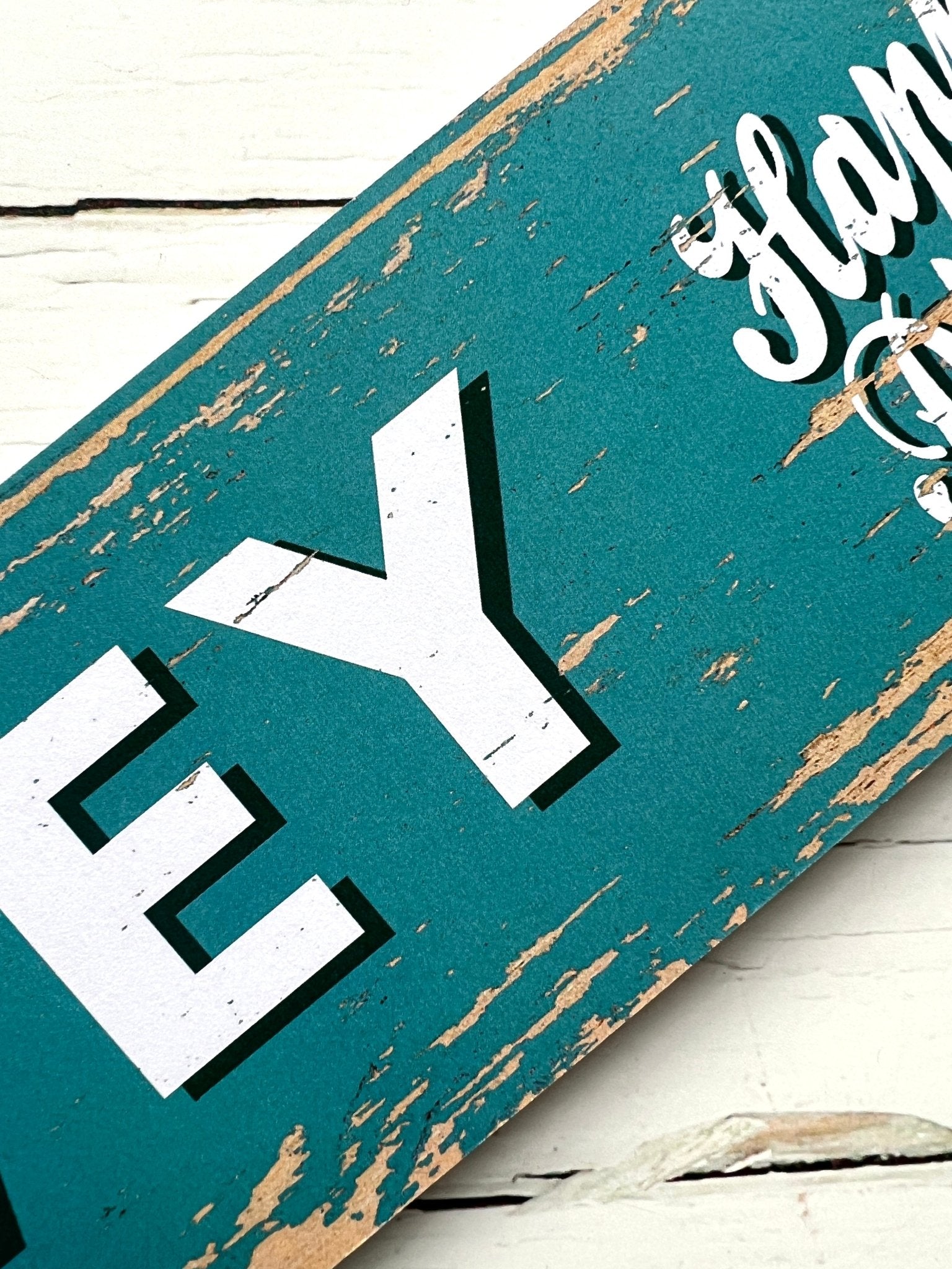 closeup shot of grey Fowey arrow sign with “Happy Place” text, rustic coastal decor, charming UK travel memento