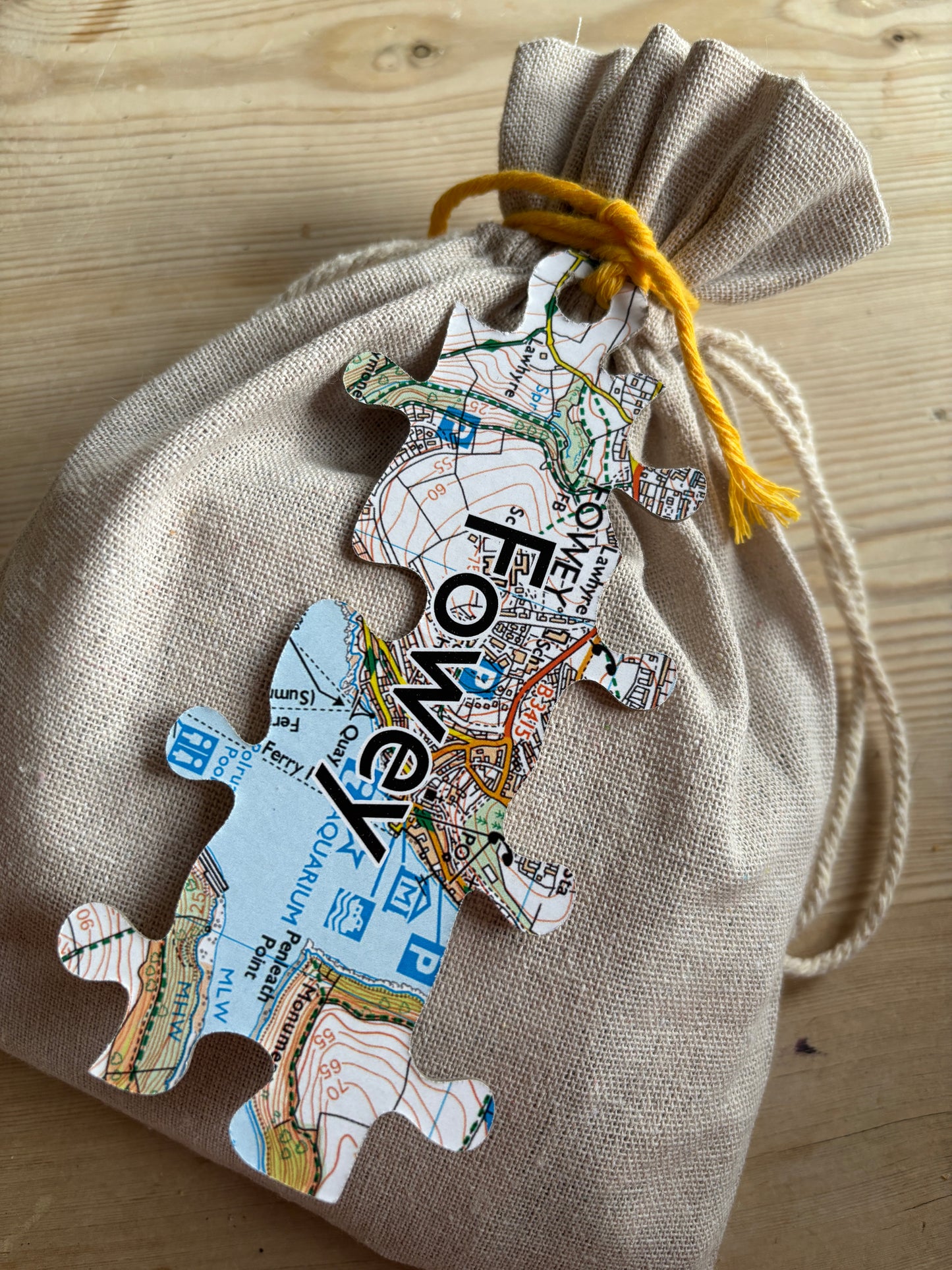 Fowey map puzzle bag drawstring calico pouch holding the lizard-shaped jigsaw local map print, a unique Cornwall souvenir game packaging