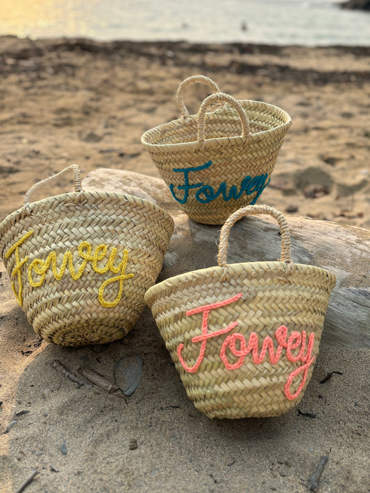 woven mini straw beach baskets with "Fowey" embroidered in yellow, pink, and teal yarn summer accessories