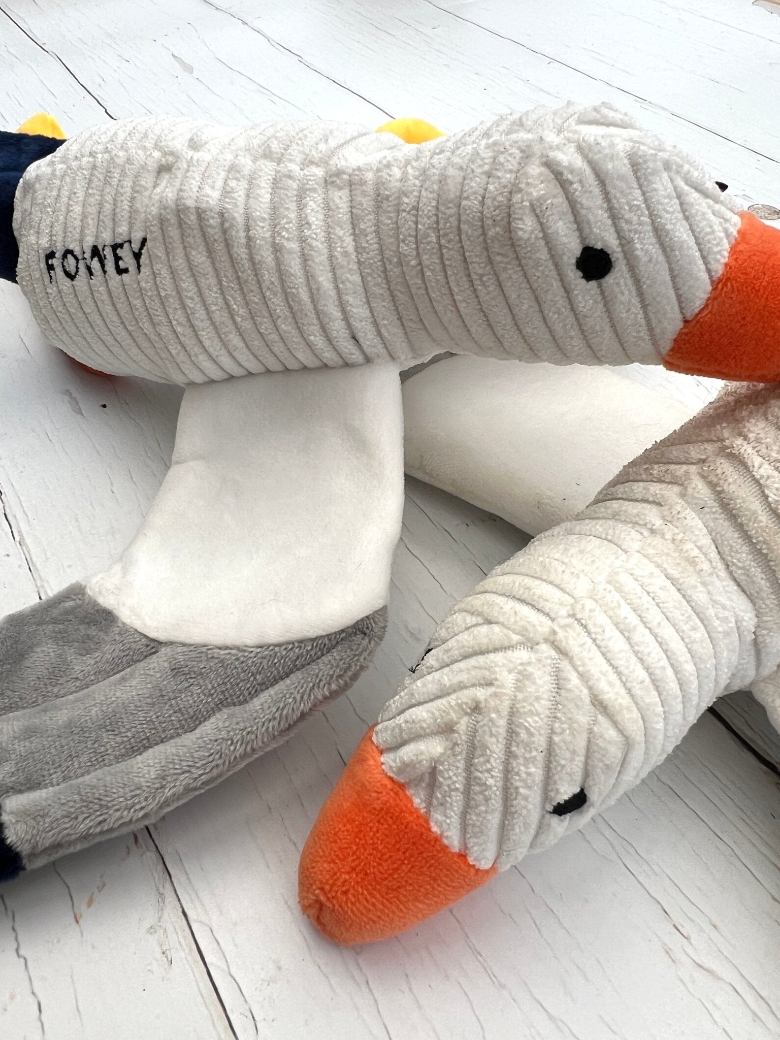 Closeup detail shot of the plush, corduroy seagull dog toy with "FOWEY" embroidery coastal pet accessory, squeaky fun