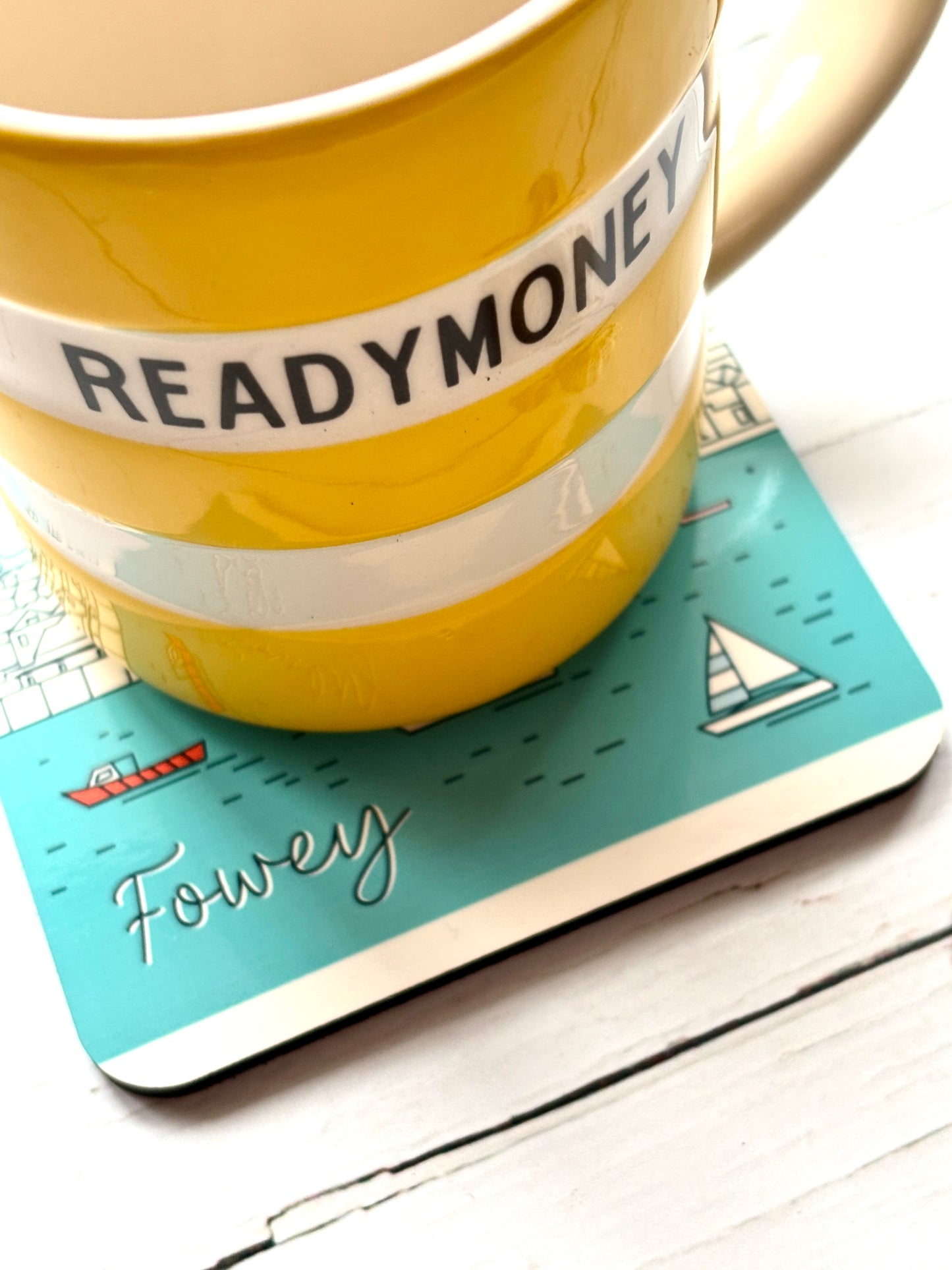 bold Readymoney mug on Fowey harbor coaster—striped ceramic and nautical illustration for coastal kitchen styling