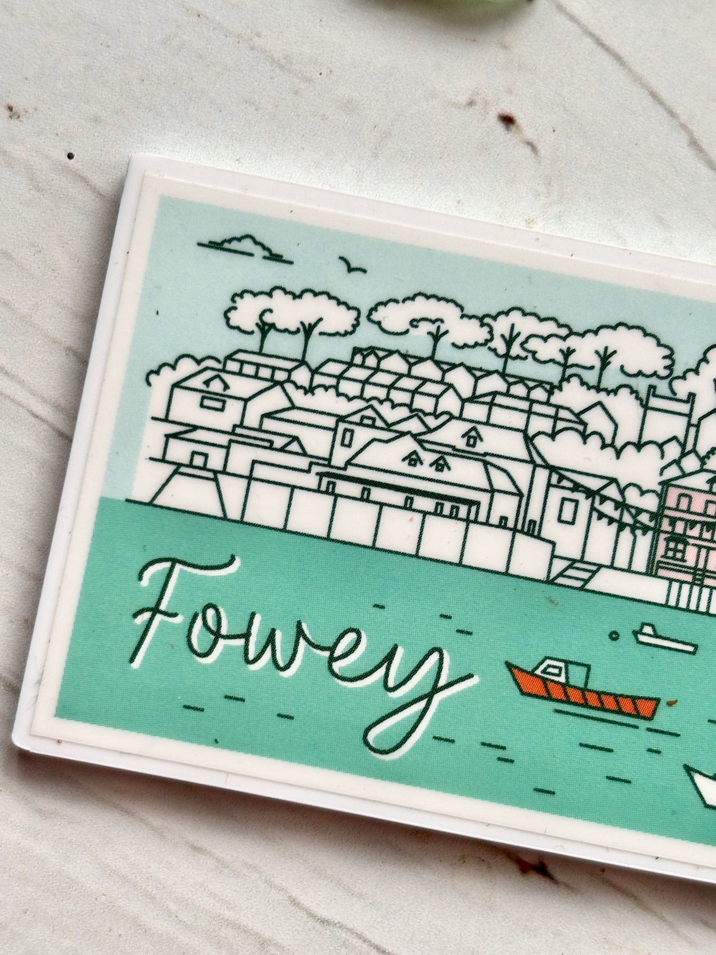 closeup shot of Fowey skyline magnet with sailboats, castle, and church spires—stylized coastal souvenir for nautical fridge decor