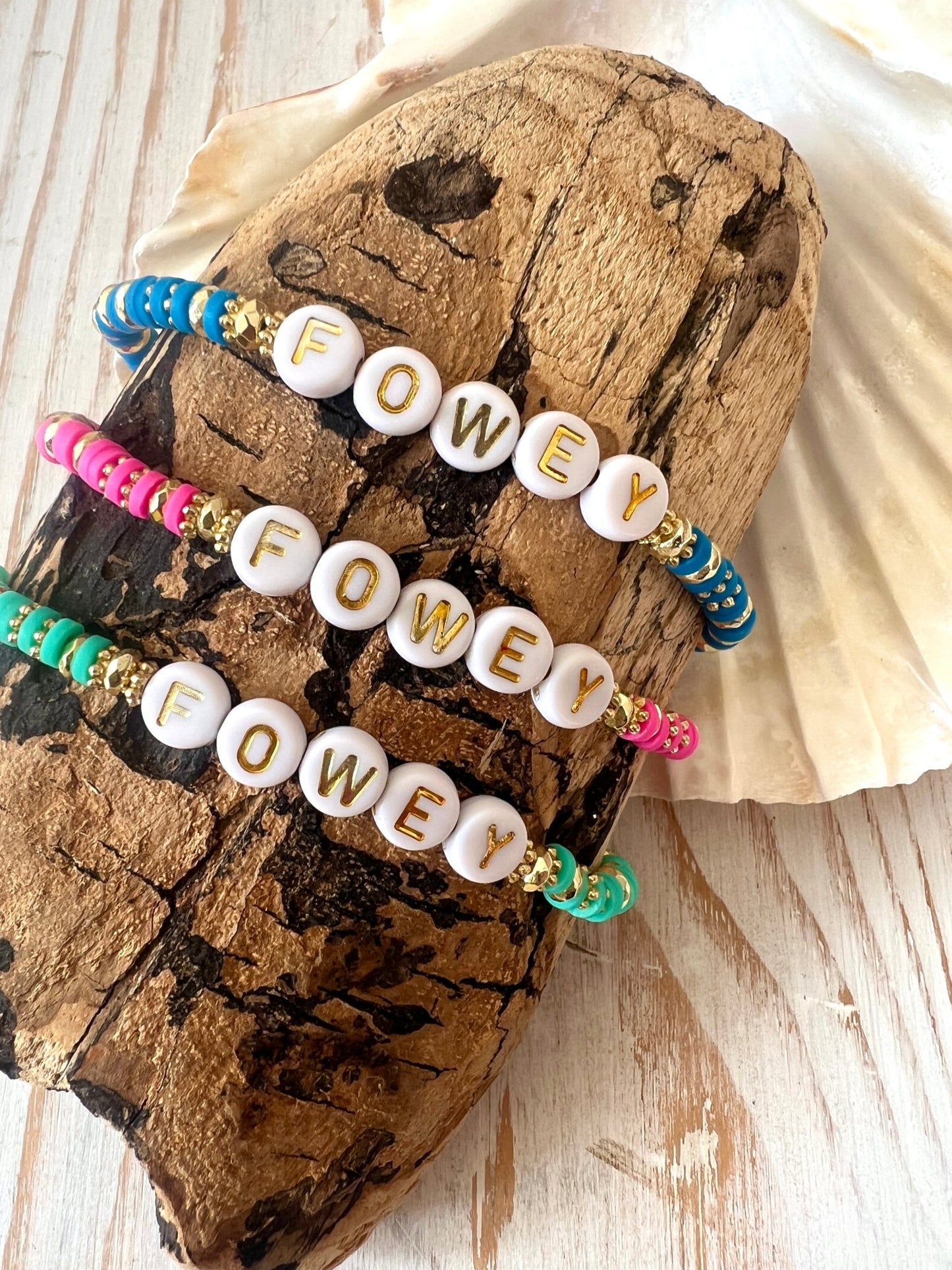 colourful sweetie-style FOWEY beaded bracelets with gold accents, coastal handmade jewellery displayed on driftwood