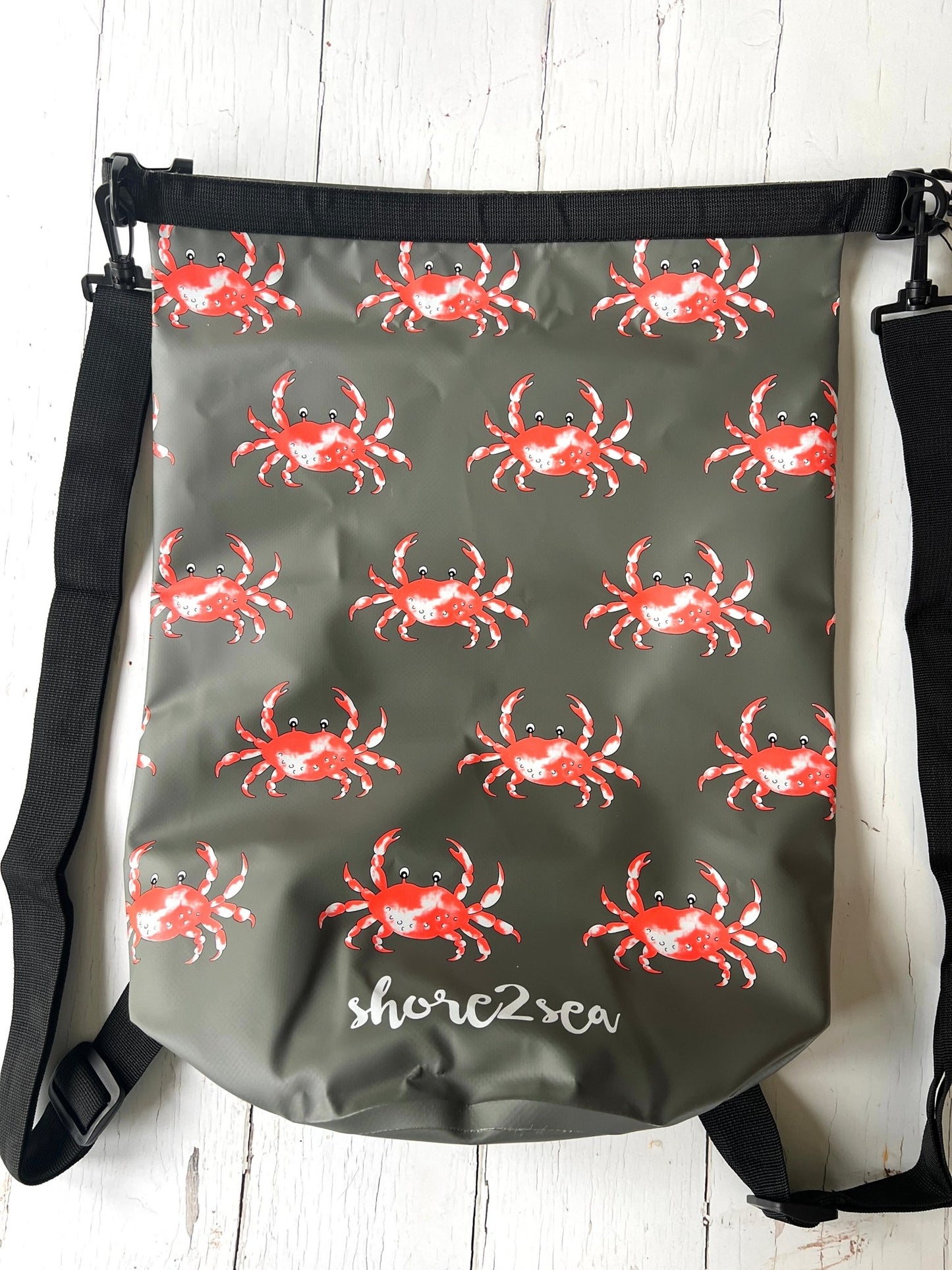 nautical waterproof dry bag in grey, patterned with repeating red and white crab graphics perfect for boating and outdoor activities