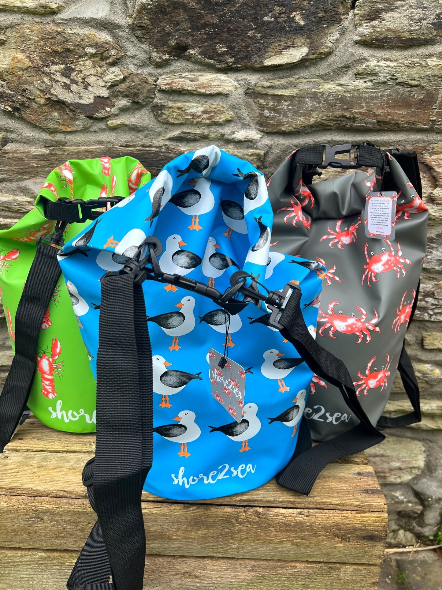colorful waterproof dry bags with crab, lobster, and seagull prints—fun nautical gear for coastal adventures
