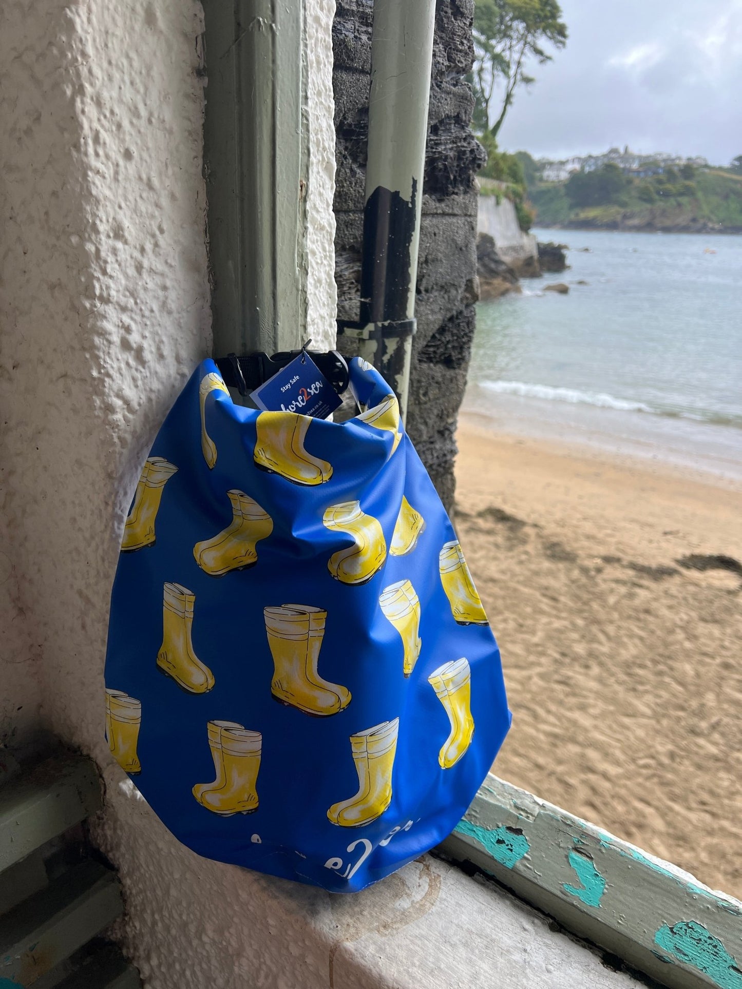 blue waterproof dry bag featuring a funky yellow wellington boot pattern ideal nautical gear for beach and wet weather