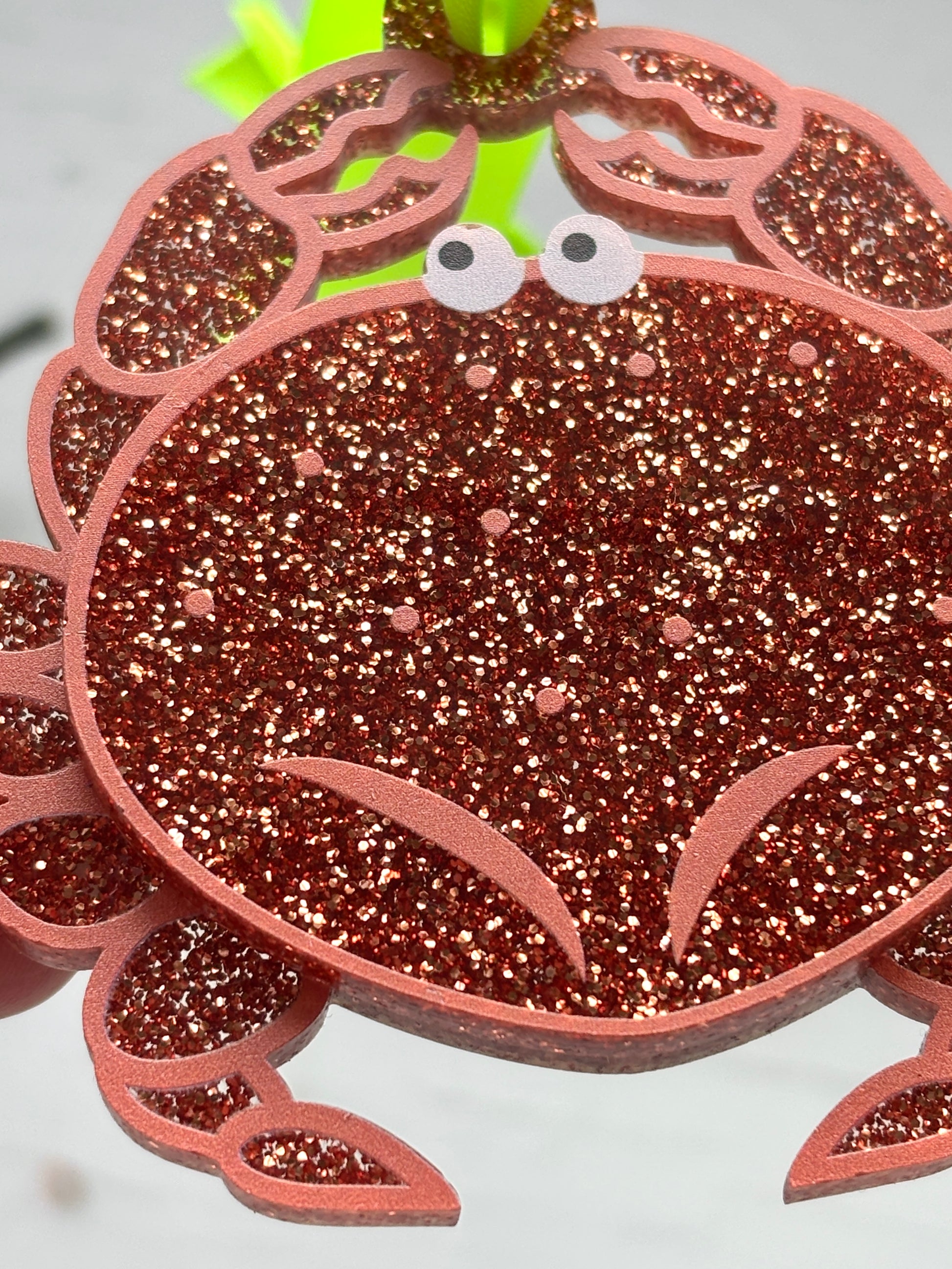 closeup shot of glittery crab Christmas decor—red sparkly ornament with cartoon eyes, perfect for coastal holiday tree styling and festive gifting