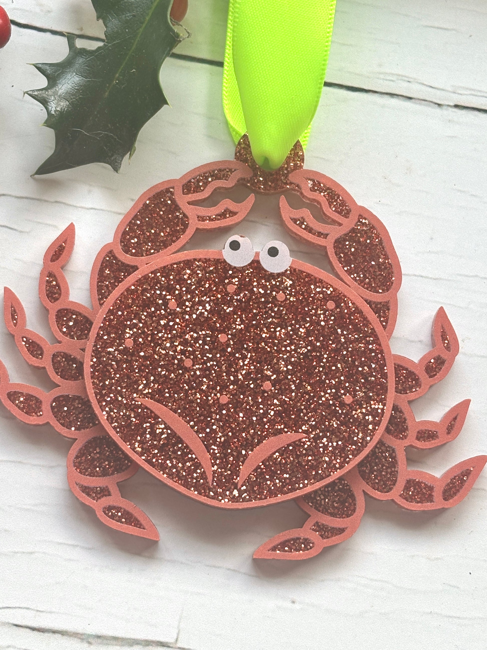 closeup shot of glittery crab Christmas decor—red sparkly ornament with cartoon eyes, perfect for coastal holiday tree styling and festive gifting