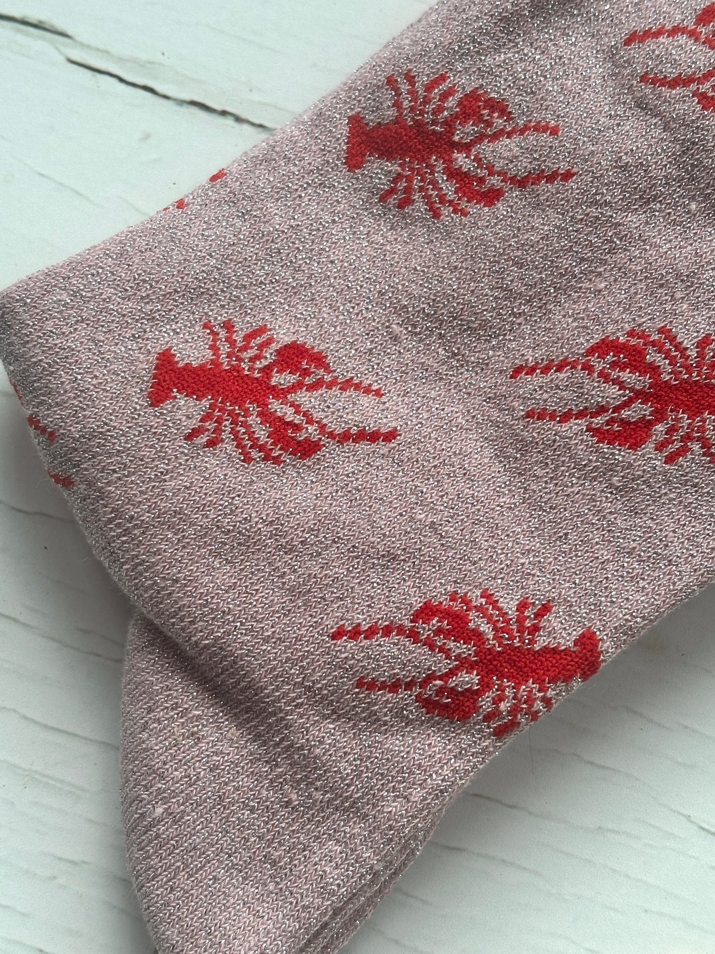 closeup shot of knit pattern of pink glitter socks with bold red lobster print unique coastal gift and novelty sea animal apparel