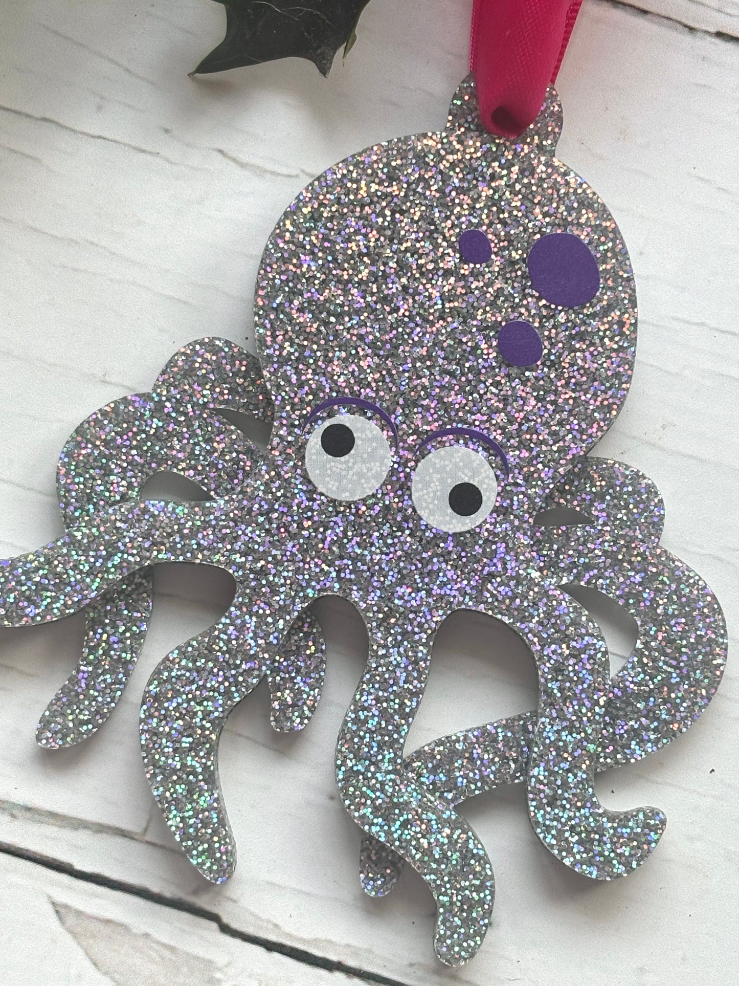 closeup shot of glittery silver octopus Christmas decoration, ocean-inspired festive ornament with purple spots and holiday sparkle
