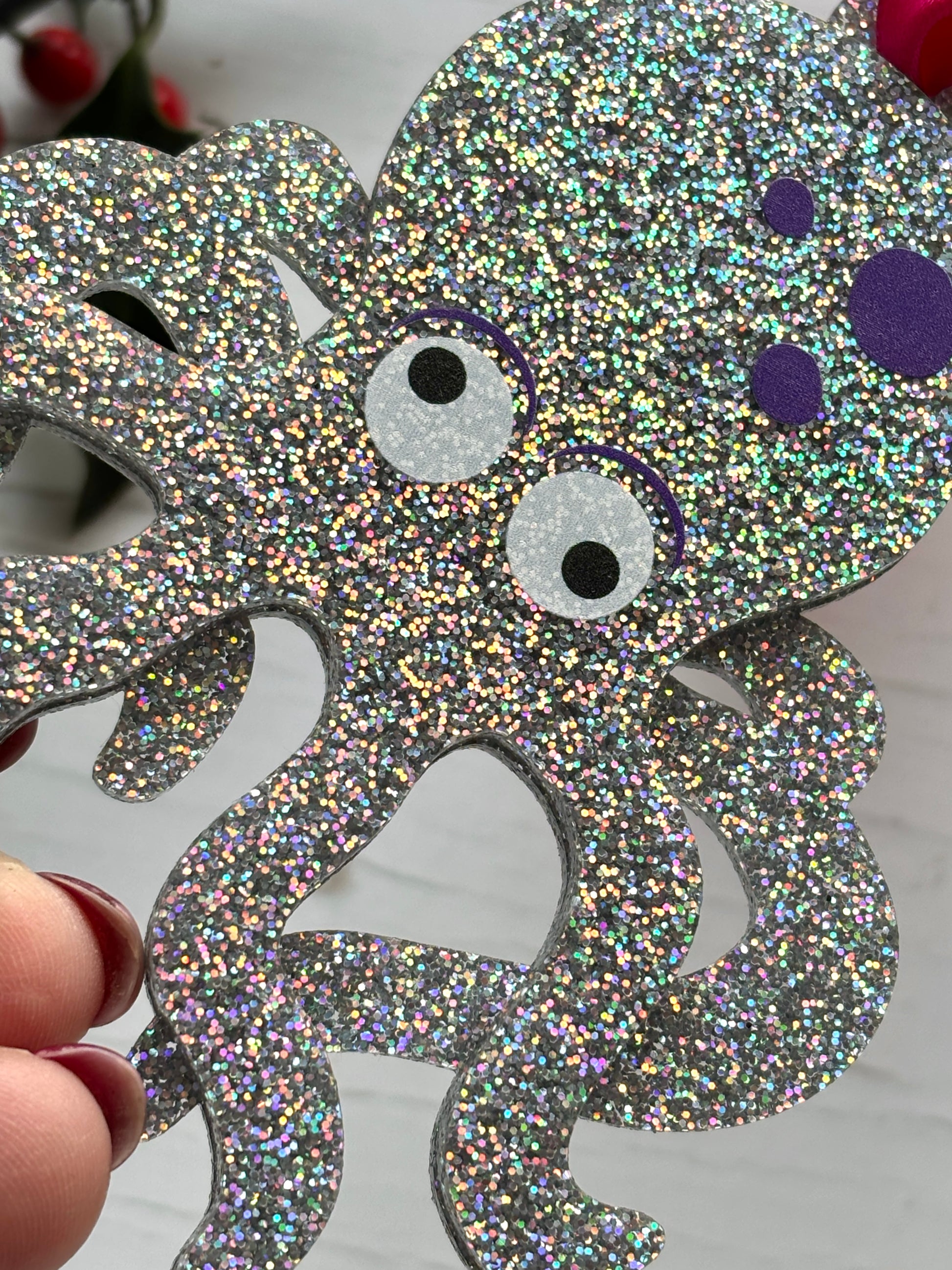 closeup shot of glittery silver octopus Christmas decoration, ocean-inspired festive ornament with purple spots and holiday sparkle